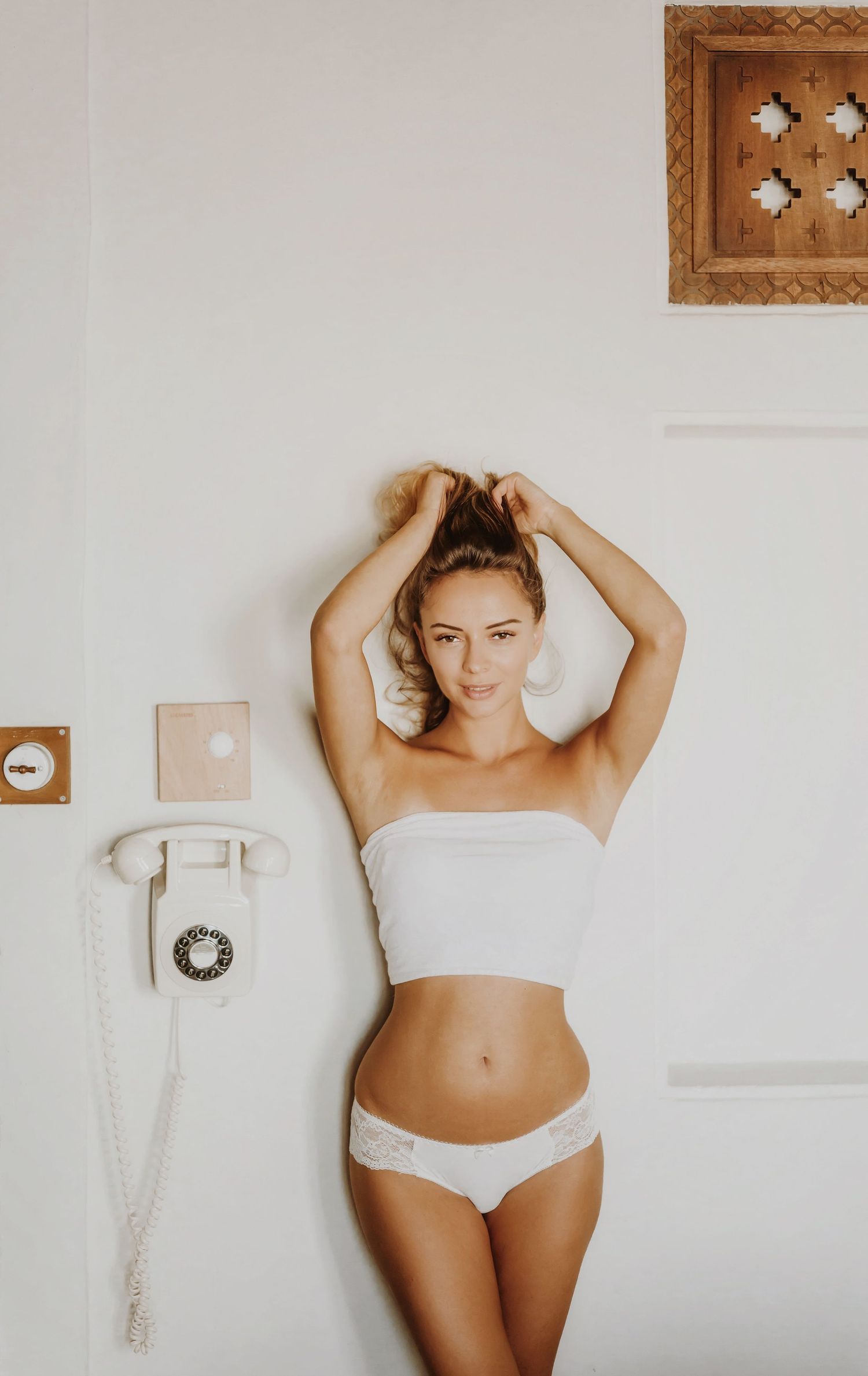 Minimalist indoor photography session with white walls and natural lighting.