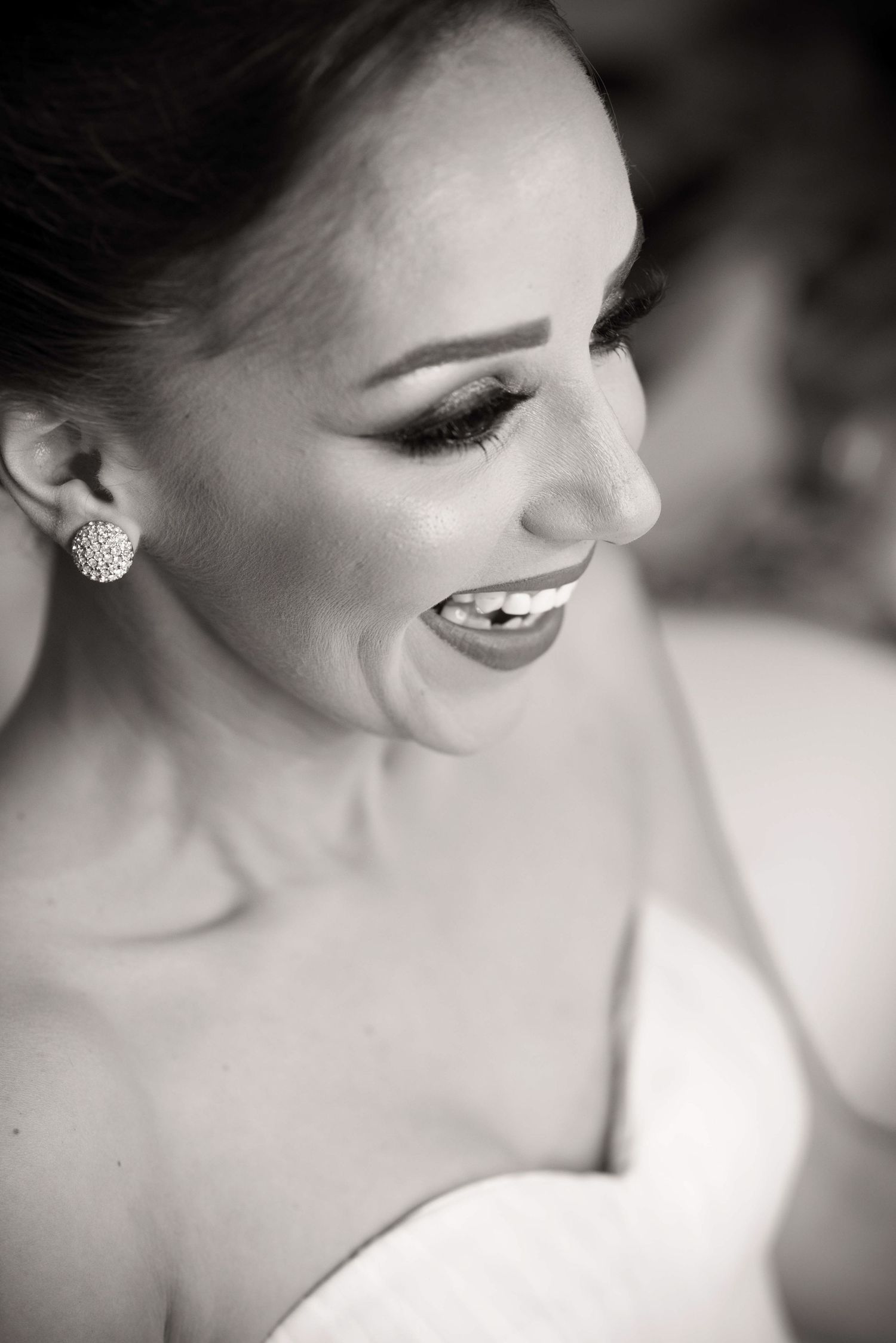 Elegant black and white portrait highlighting delicate makeup and jewelry details.