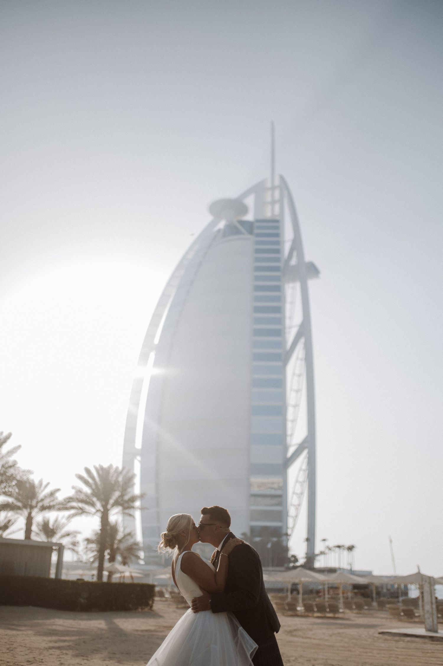 Romantic silhouette against Dubai's Burj Al Arab hotel during golden hour.