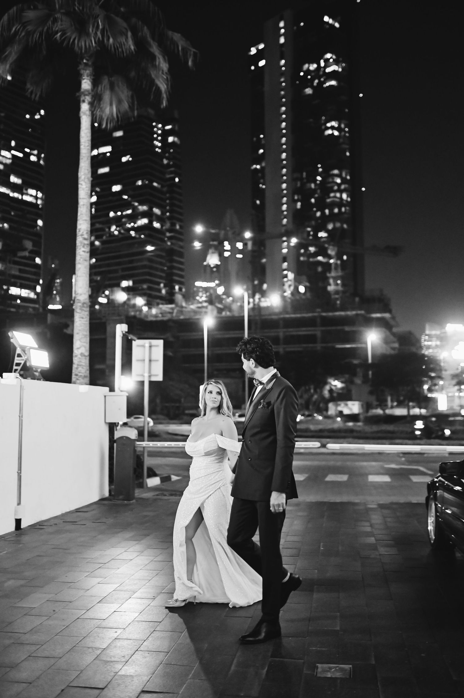 Nighttime wedding photography with illuminated skyscrapers in the background.