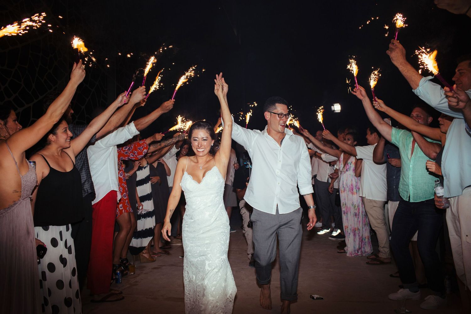 People dancing with raised arms at a nighttime celebration or party.