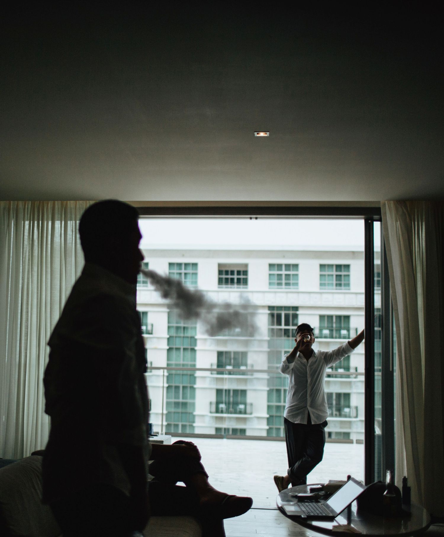 Dramatic silhouettes against large windows in a modern building.