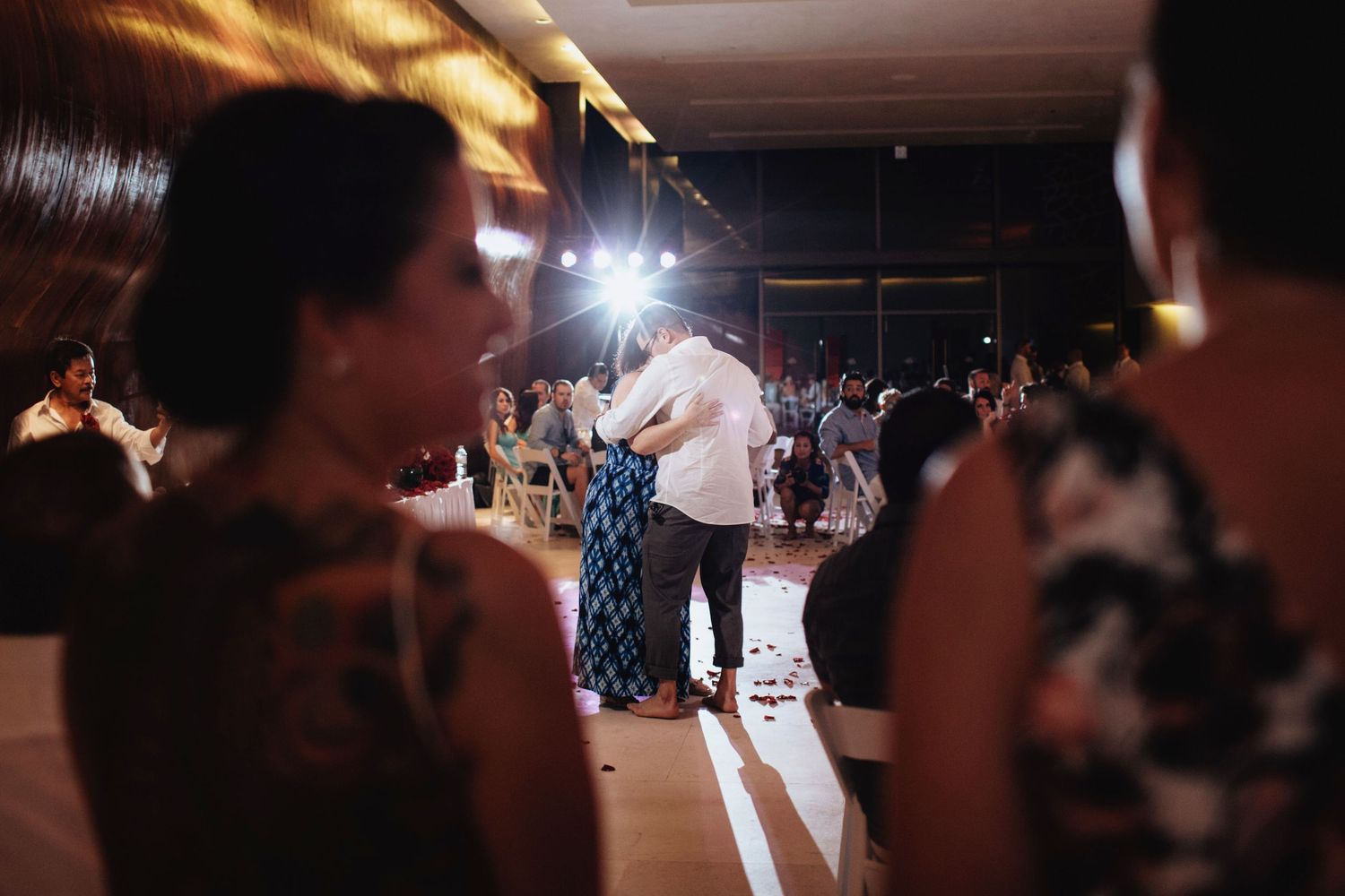 A couple performs a dance routine in a warmly lit reception hall.