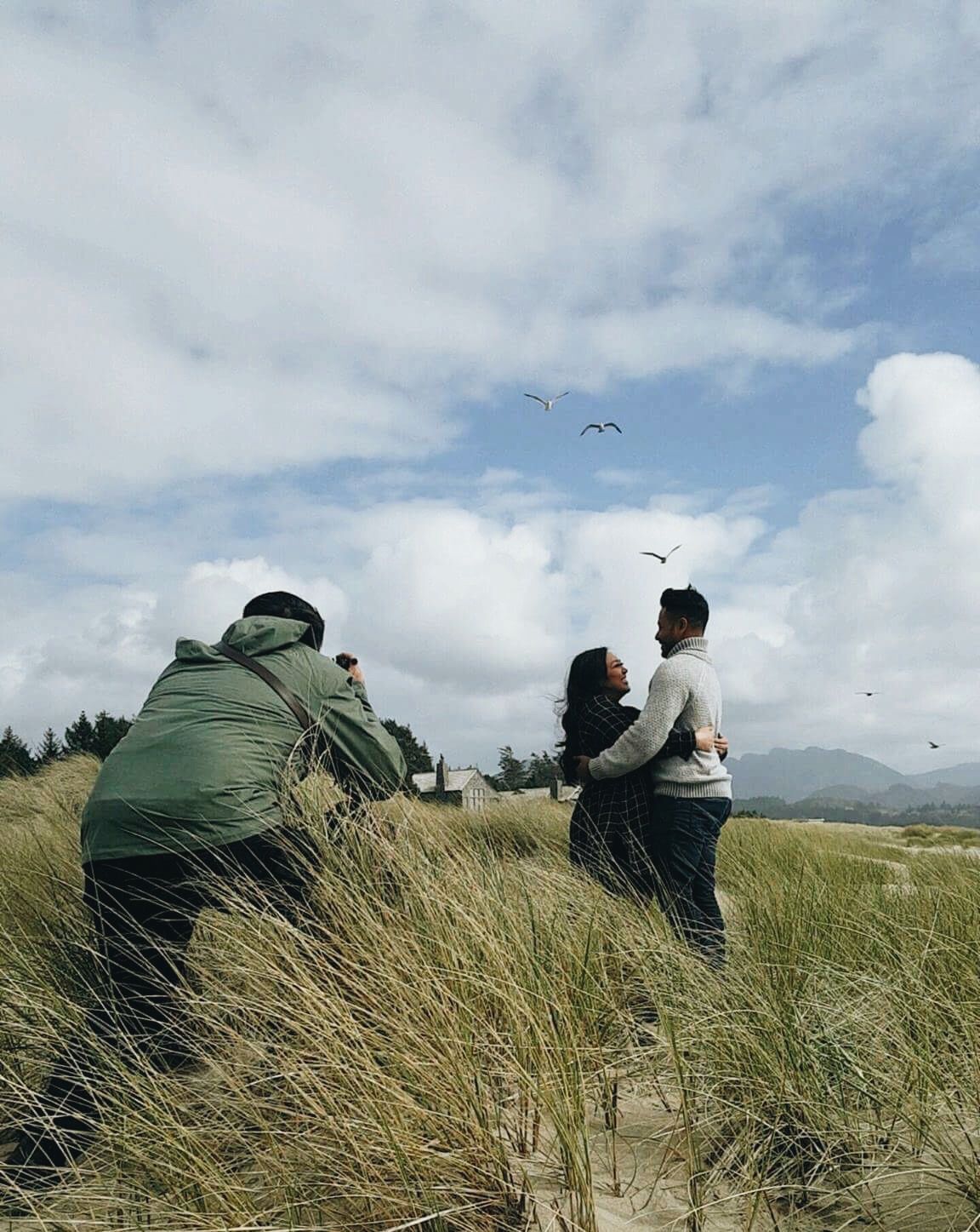 People watching birds on a windy coastal hill with tall grass and cloudy skies.
Jojo Pangilinan Photographers, Dallas based Destination wedd