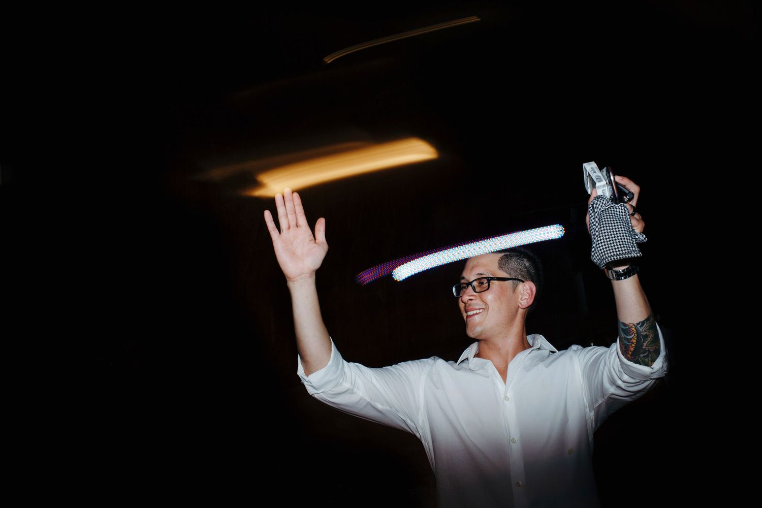 People taking selfies with phones in dark lighting conditions.