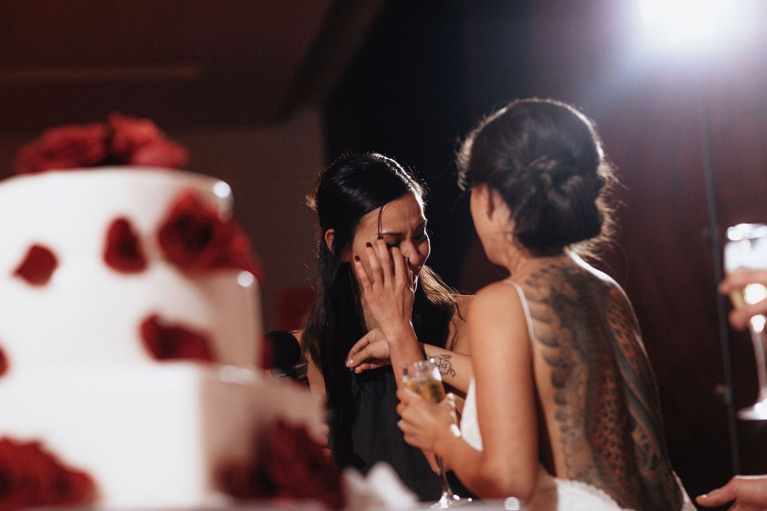 Dancers perform energetic moves at a reception with dramatic lighting and rose petals.