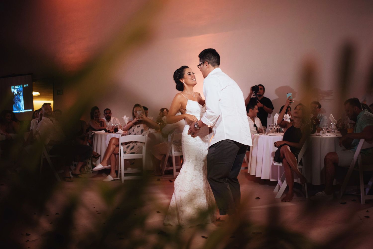 Dancers perform at a dimly lit reception with guests watching in the background.