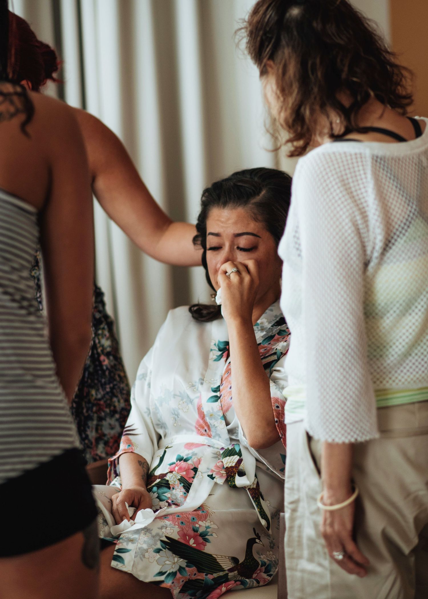 People in summer clothing arranging details in a bright interior room.