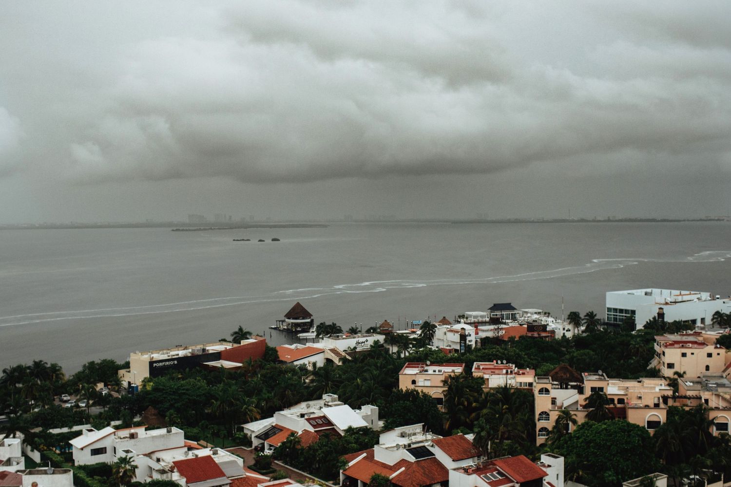 Panoramic view of storm clouds gathering over coastal buildings and homes.