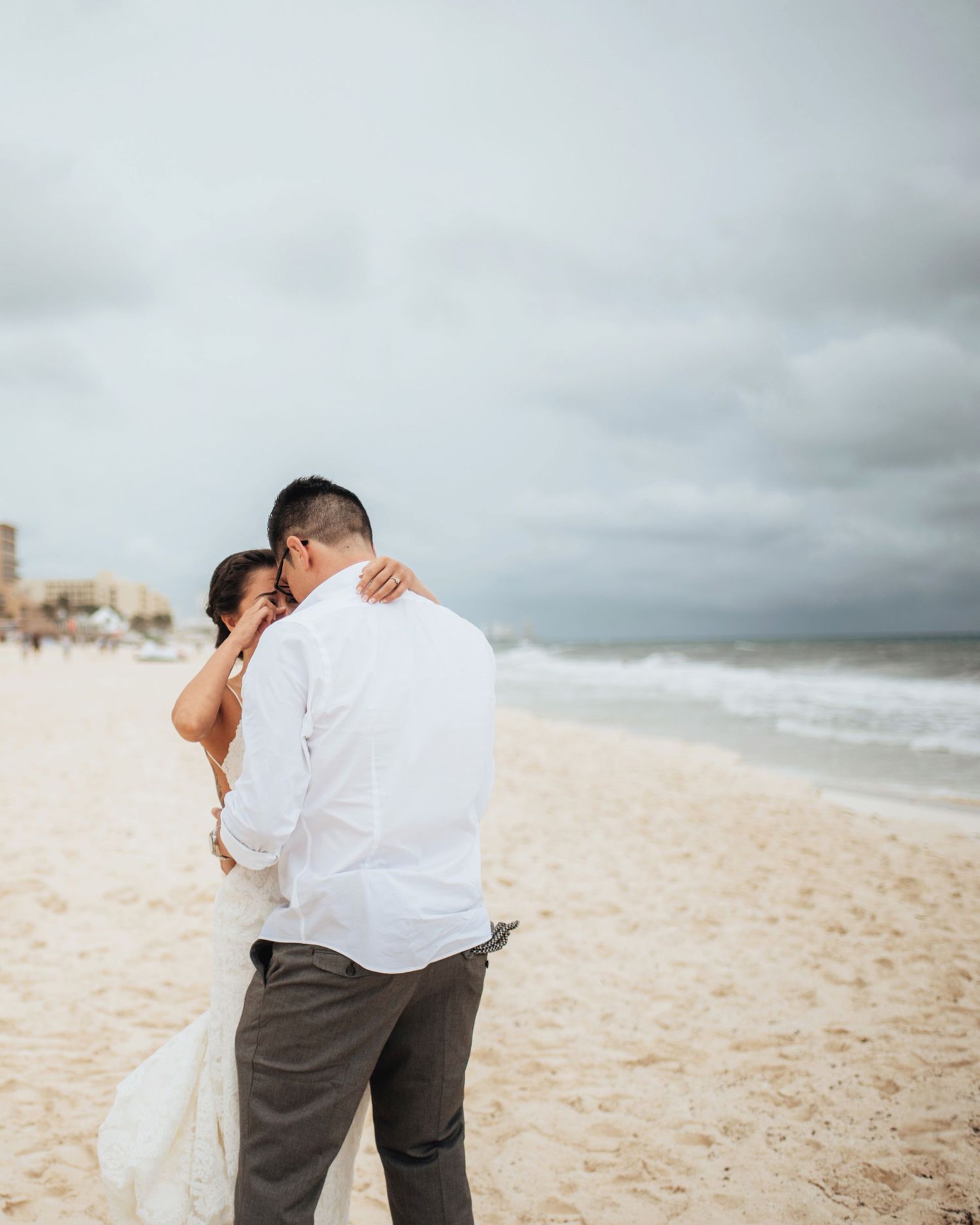 Intimate beach moment captured with overcast skies and rolling waves.