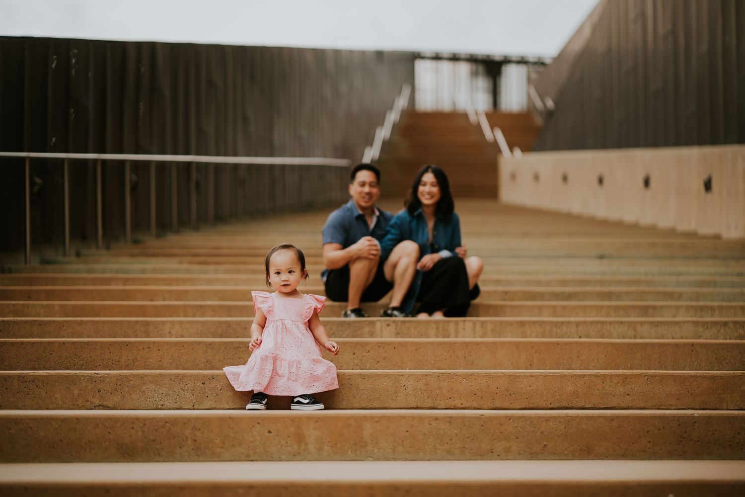 Family portrait session on concrete steps with warm lighting.
