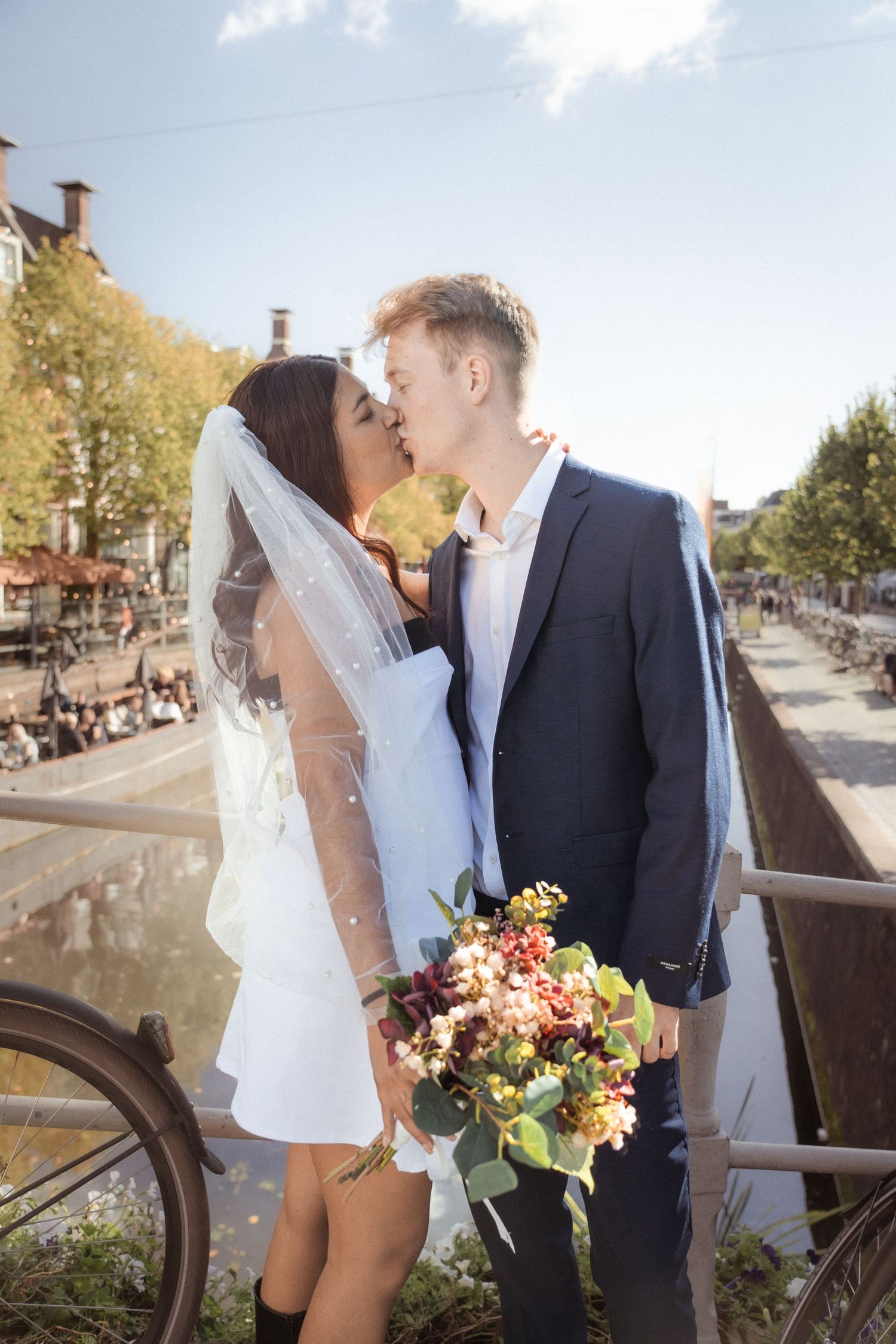 Romantisch stel kust bij de gracht in Leeuwarden – tijdloze liefde vastgelegd in een prachtig decor.