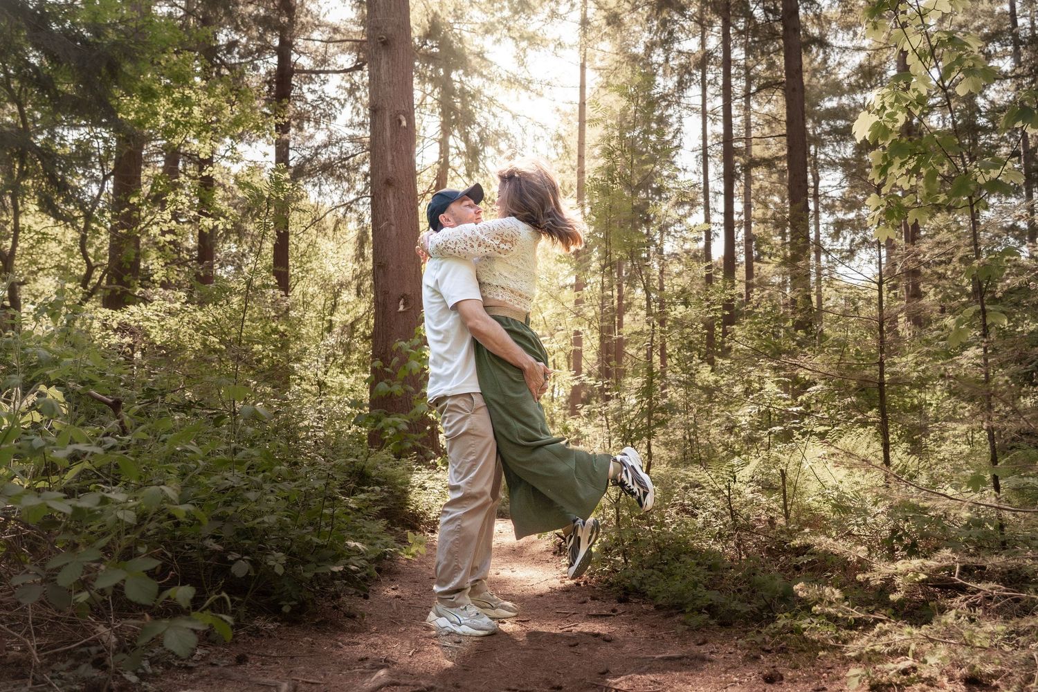 Romantische koppelfoto in het bos bij Leeuwarden – spontaan, natuurlijk licht, vastgelegd door een buitenfotograaf voor stellen.