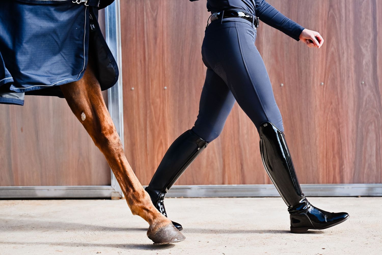 Close-up of feet in black riding boots and breeches during an equestrian lesson.