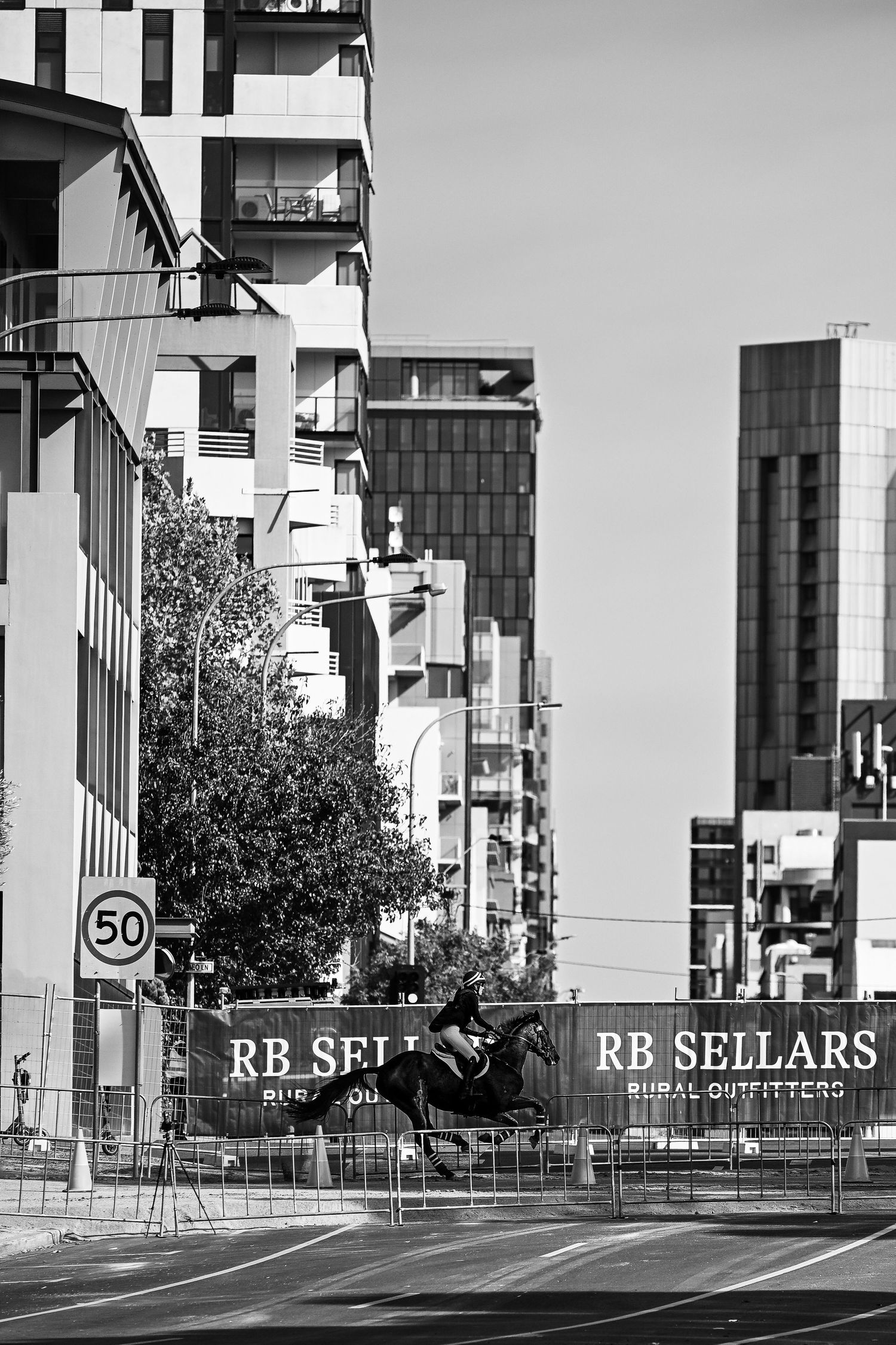 Urban street scene with modern buildings and RB Sellars signage in black and white.
