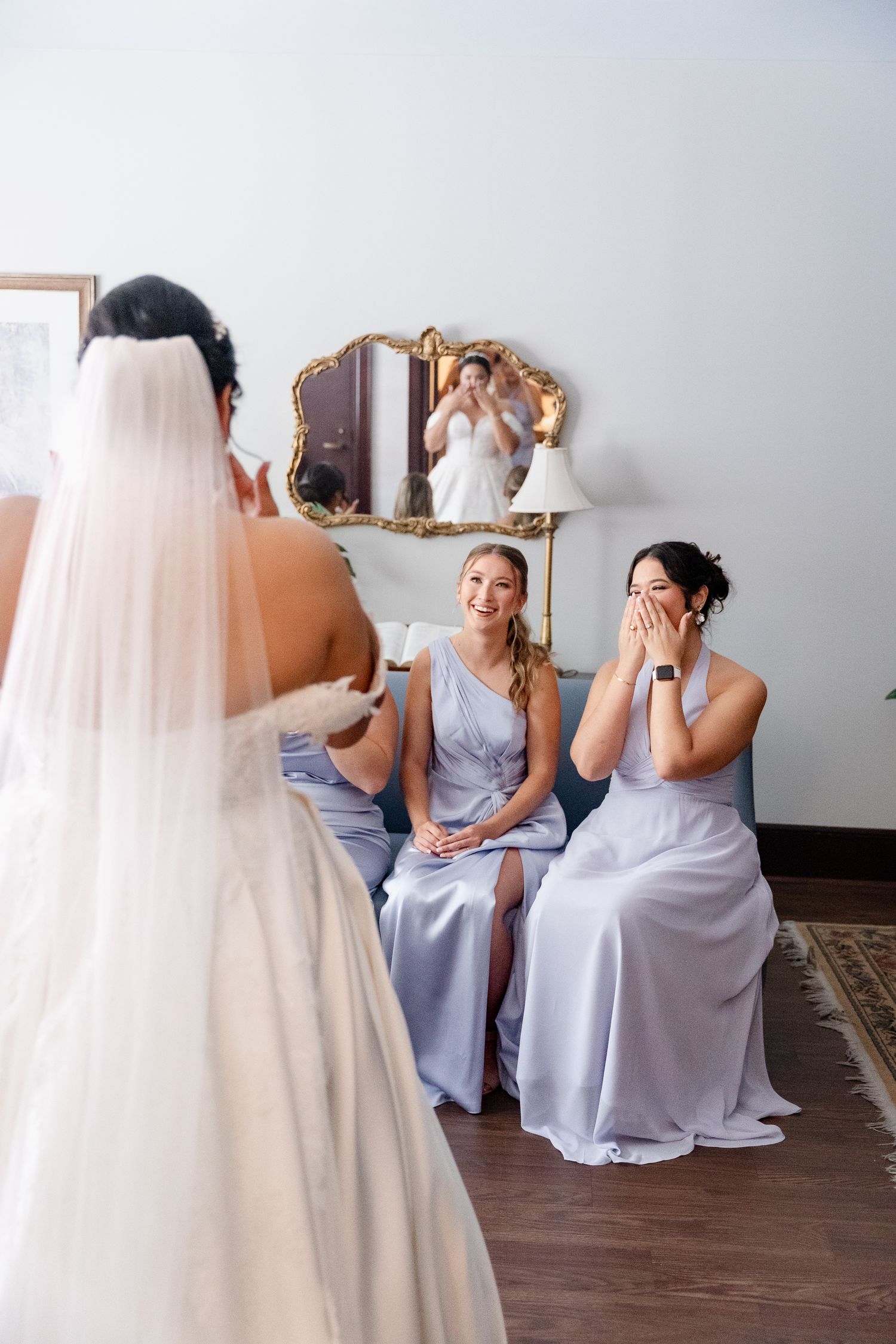 Emotional reveal moment with bridesmaids in light blue dresses reacting to bride.