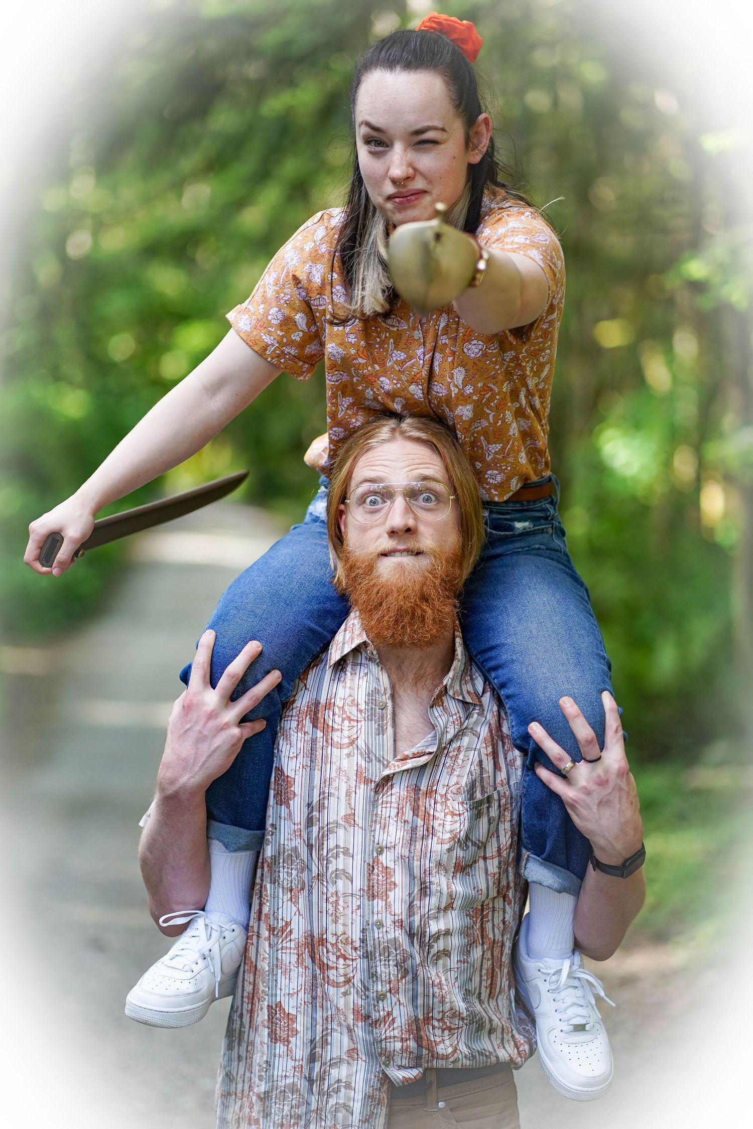 A fun shoulder ride pose captured in a dreamy forest setting with soft bokeh background.