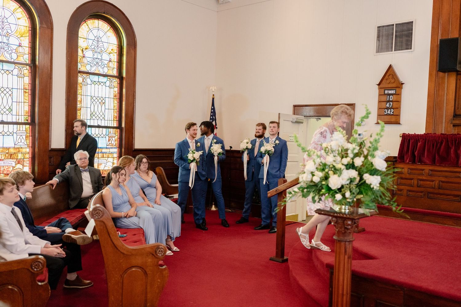 A series of wedding ceremony photos showing moments inside a traditional church with stained glass windows and red carpeting.