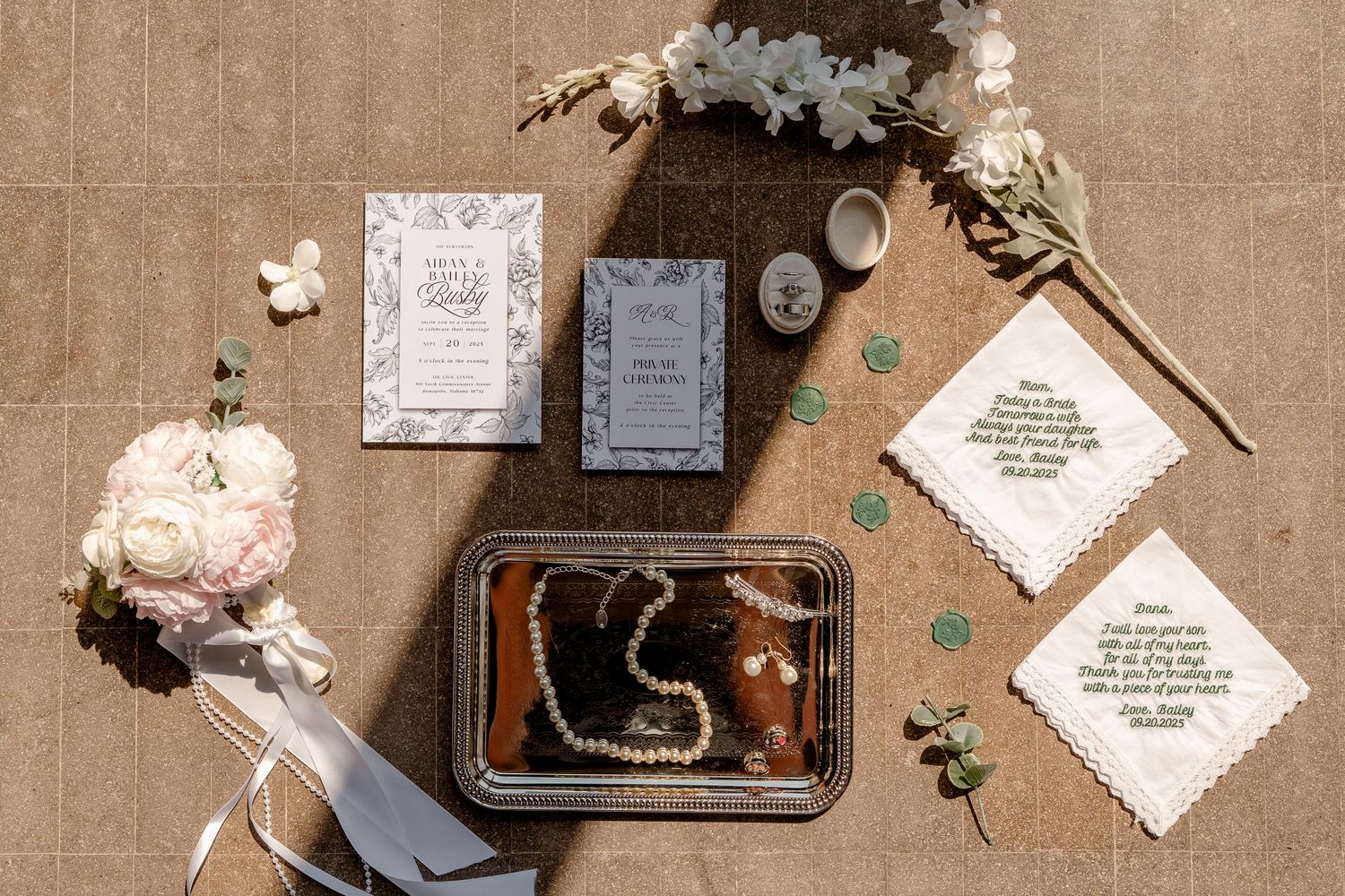 Vintage wedding invitations and decorative elements arranged on a beige textured background with dried flowers and ribbons.