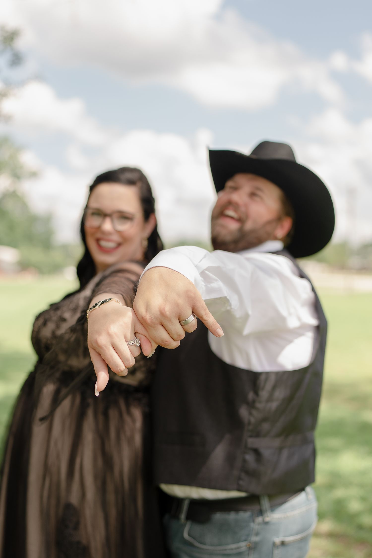 Happy couple embraces and laughs during outdoor wedding photoshoot.