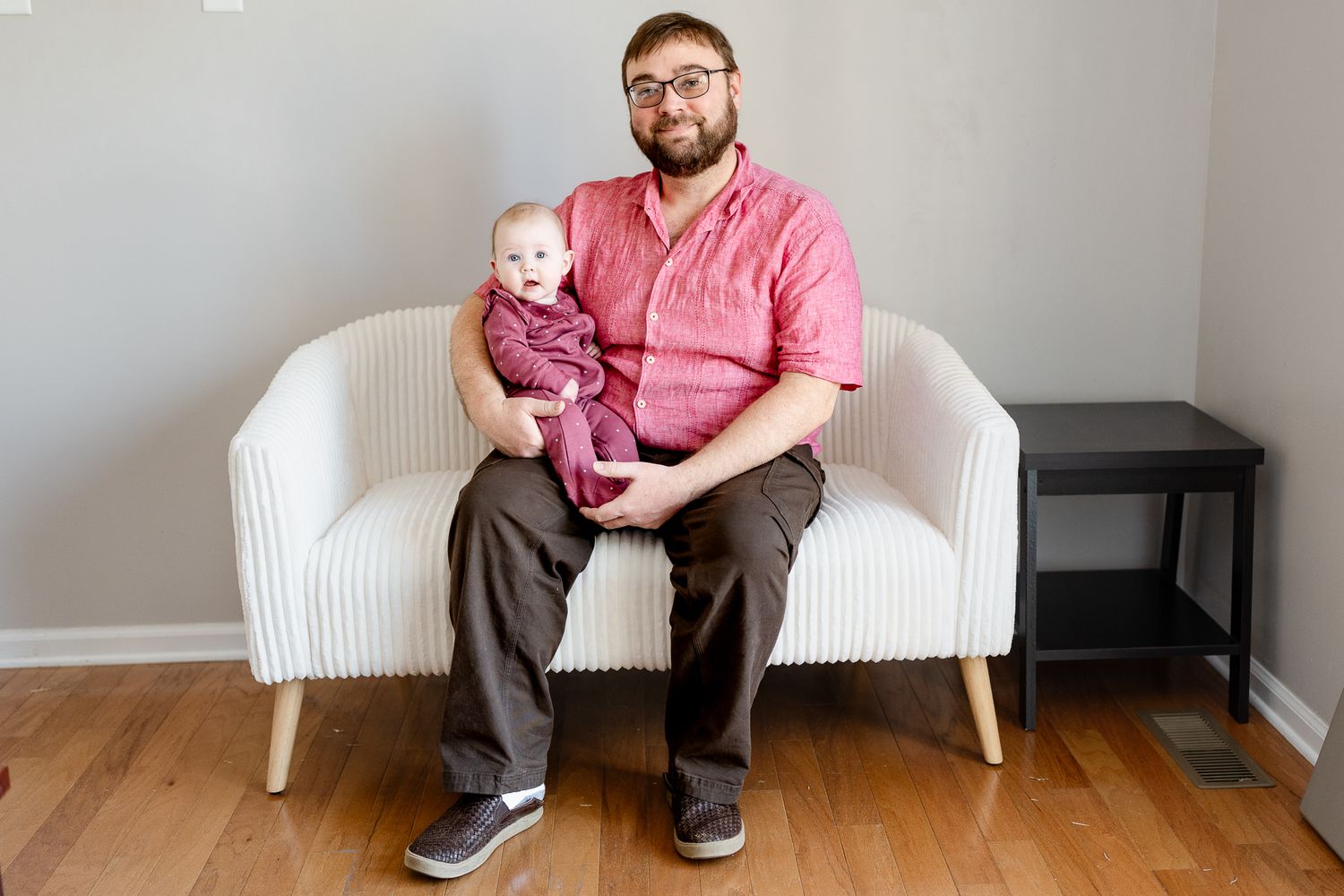 Person sitting on modern white couch in casual attire.