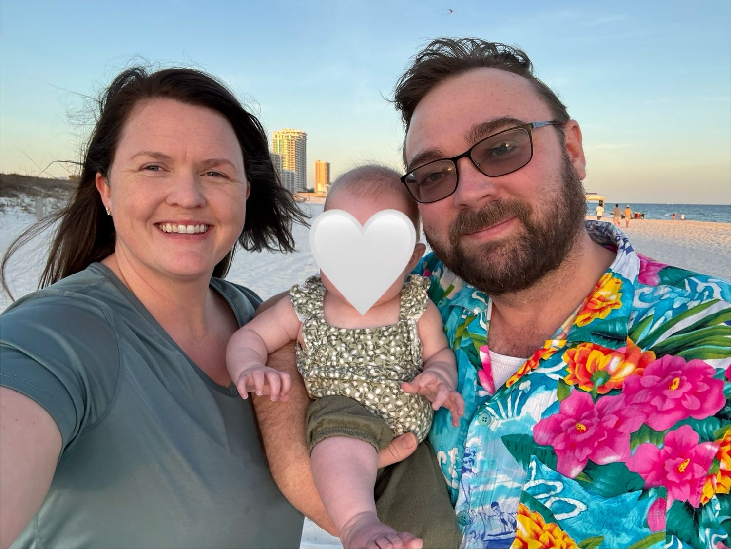 A couple enjoys a sunset beach date wearing colorful tropical shirts.