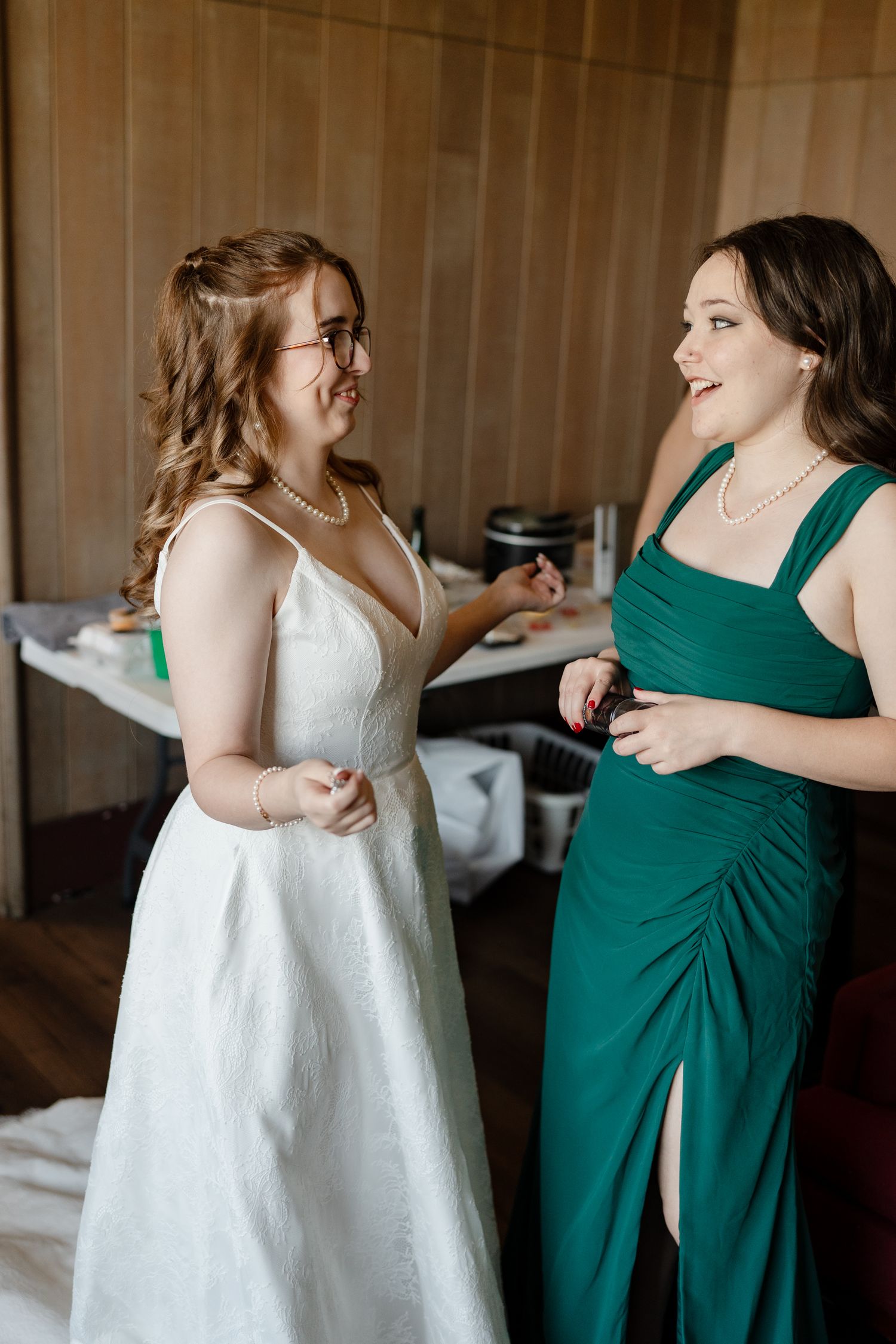 A series of candid getting ready moments showing a bride in white and bridesmaid in emerald green dresses.