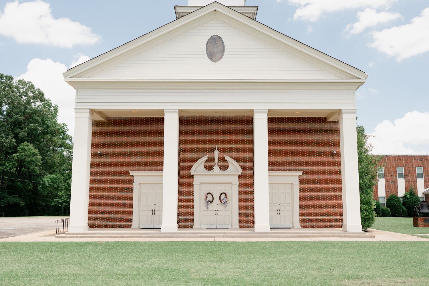White church exterior with red brick walls and classical columns photographed from multiple angles.