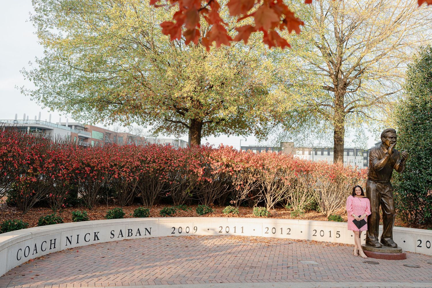 A panoramic view of a brick pathway winding through autumn trees with vibrant red and gold foliage.