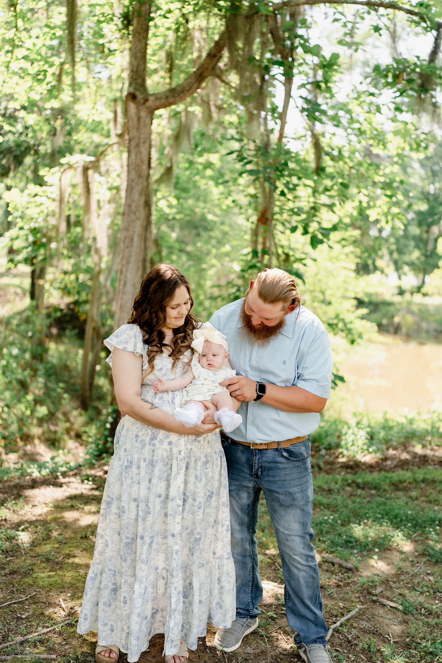 Family enjoying playful moments together in a serene forest setting.