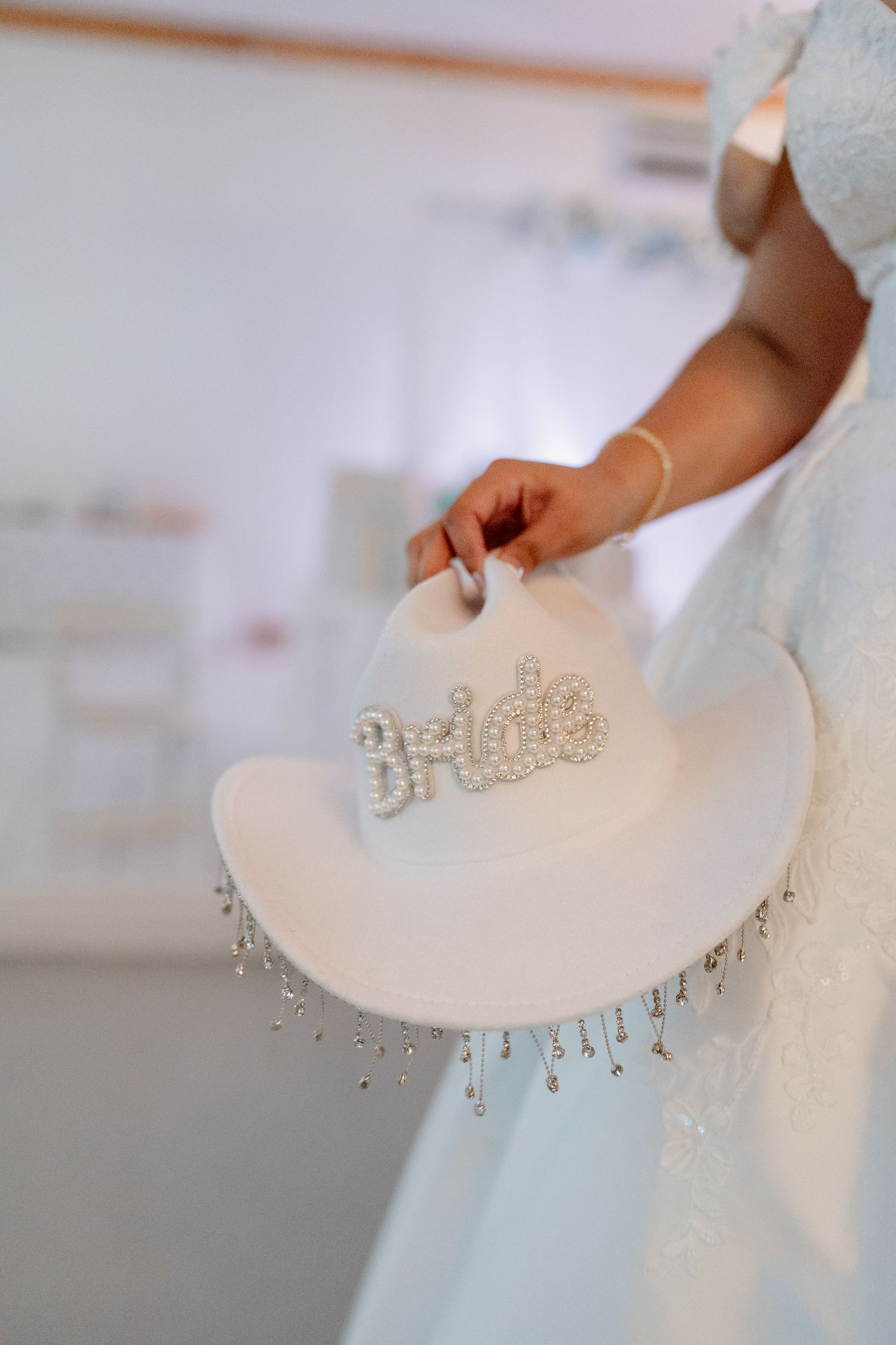 Close-up detail of delicate crystal embellishments on white wedding dress fabric.