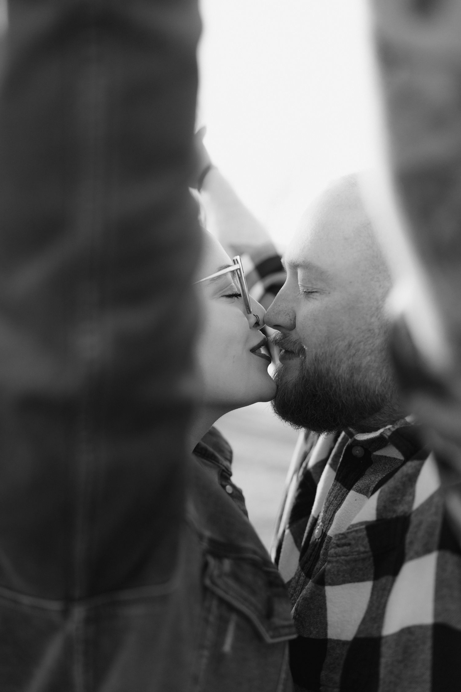An intimate black and white close-up portrait of a couple sharing a tender moment together.