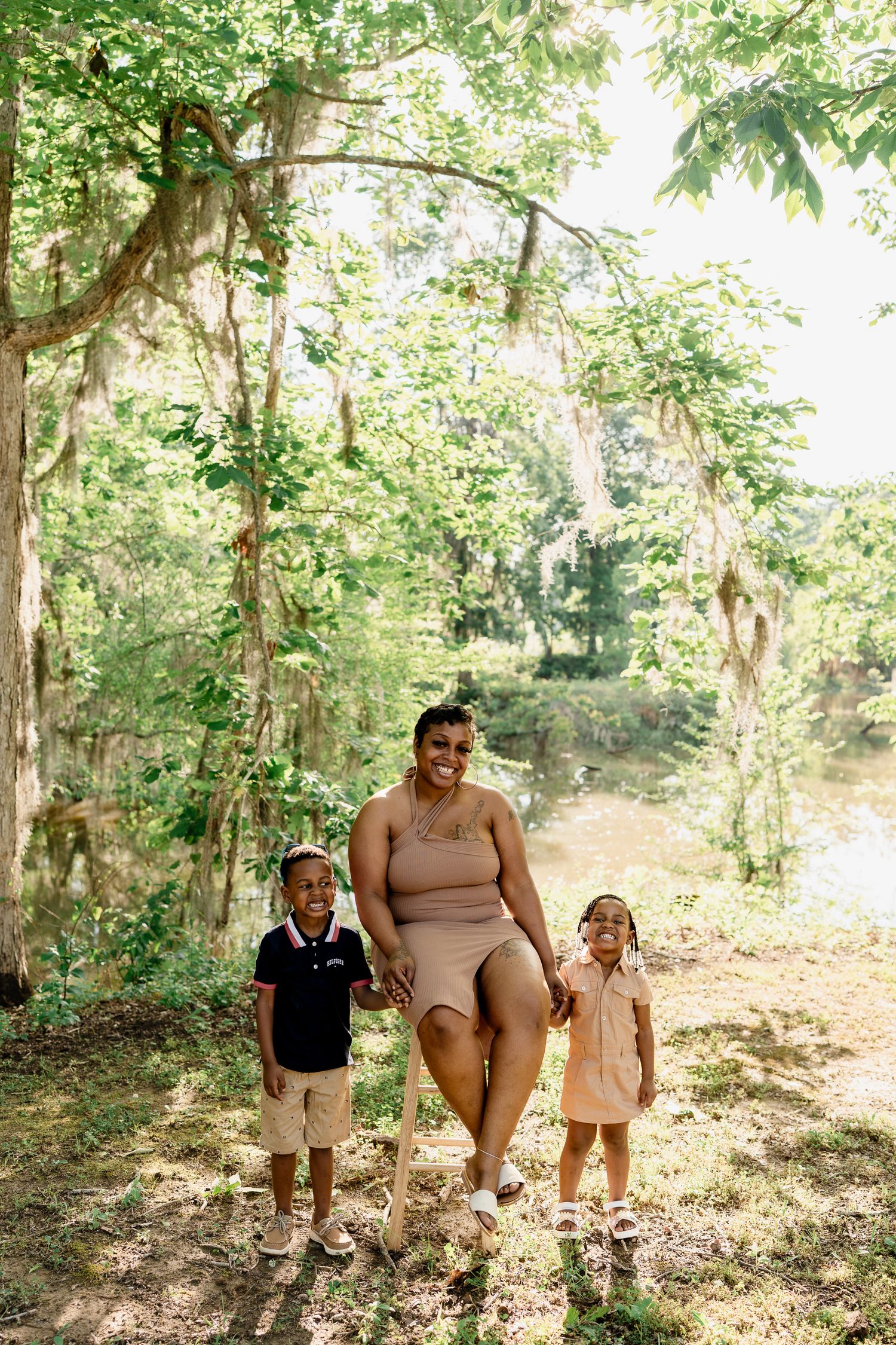 Family group enjoying a nature walk together in a scenic wooded area by the water.