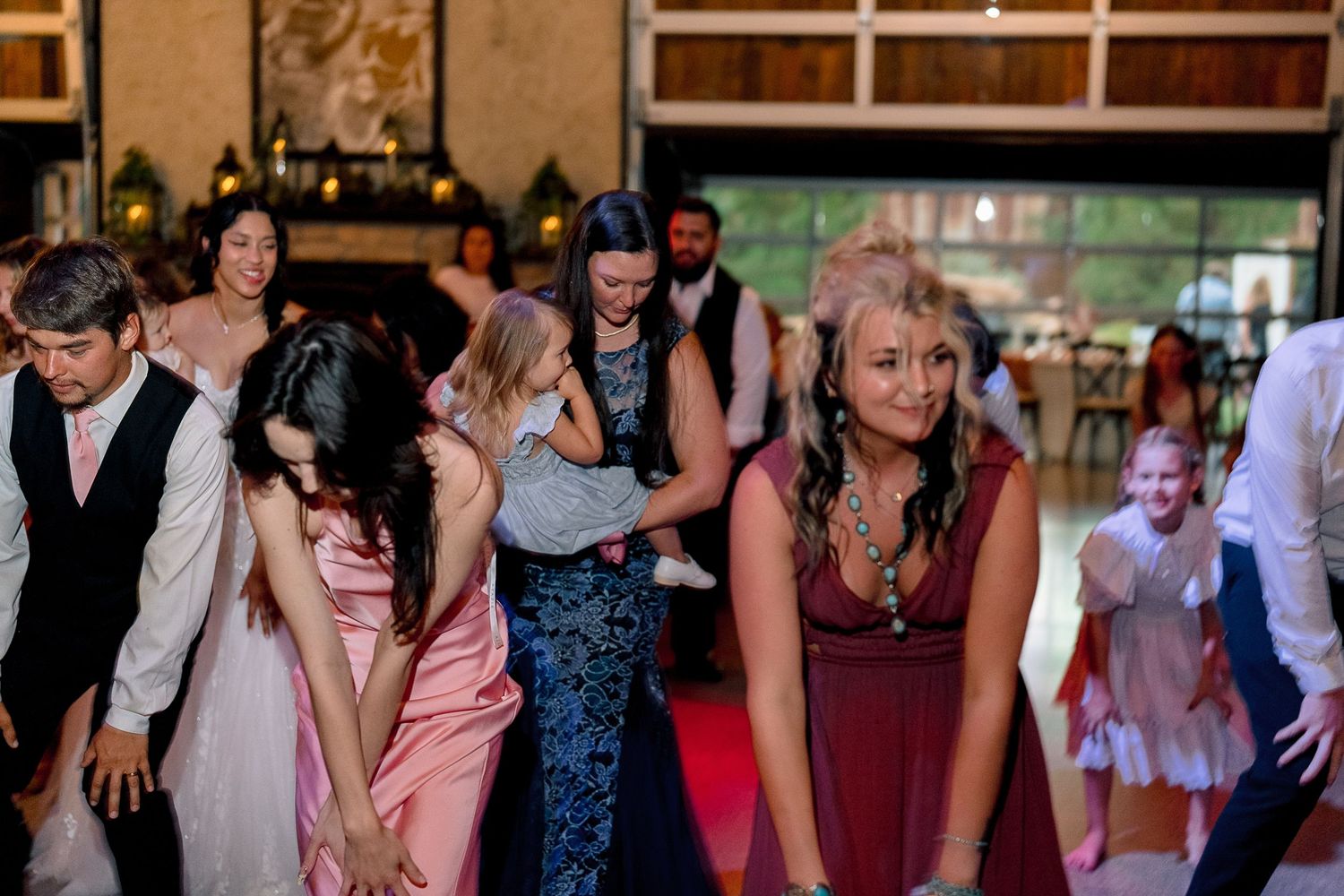 Guests dancing and celebrating at an elegant wedding reception in a beautifully decorated venue.