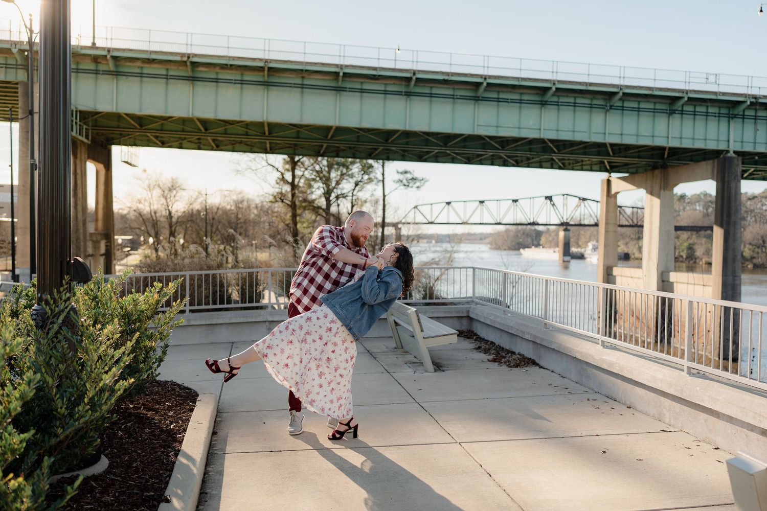 Dancing figures spin and twirl under an overpass during an outdoor photoshoot at dusk.