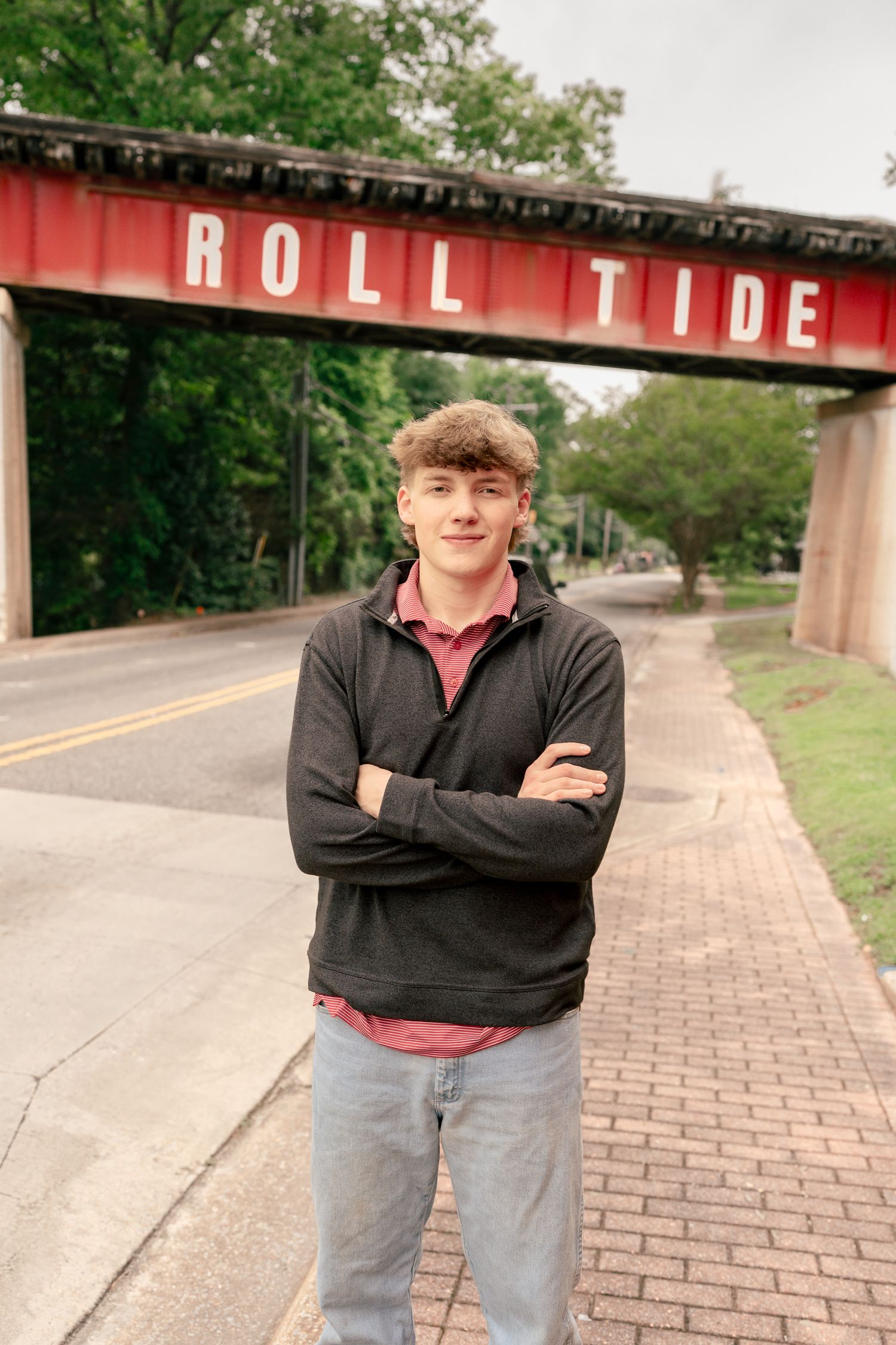 A student poses confidently under the Roll Tide bridge at the University of Alabama.