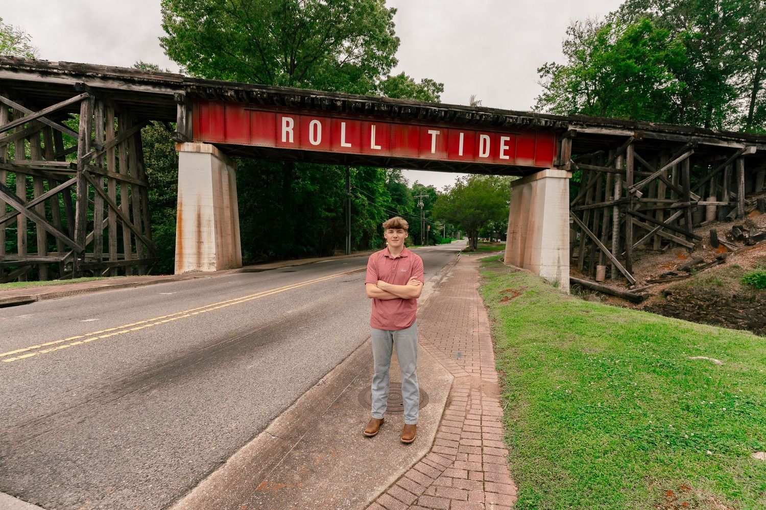 A view of the iconic Roll Tide bridge at the University of Alabama with a person standing beneath.