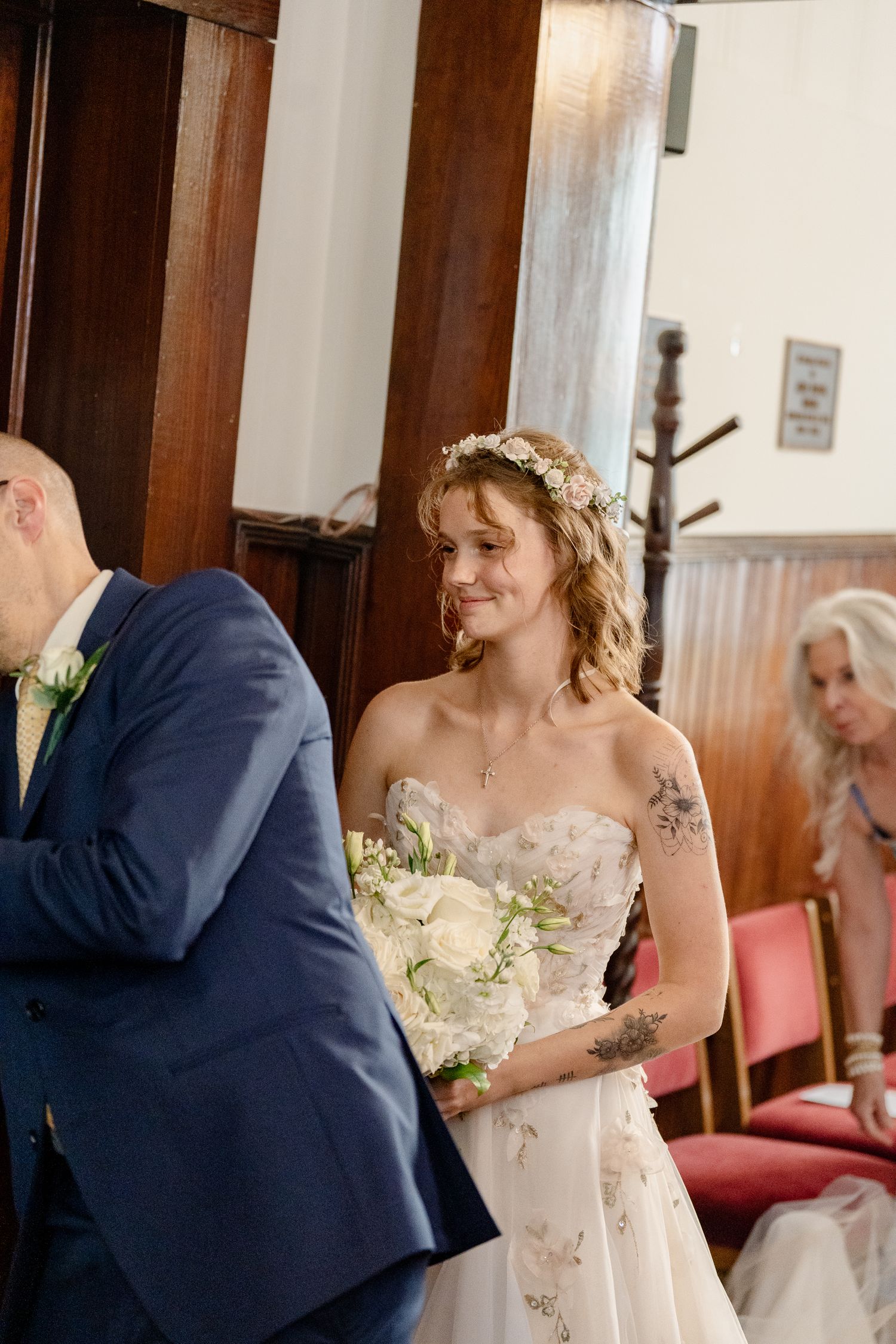 A series of wedding photos showing a bride in a white dress and groom in navy suit during their first look moment.