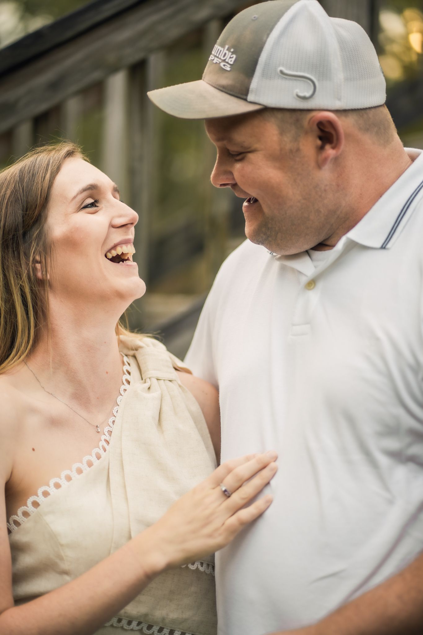 A couple shares joyful laughter during their outdoor photo session.