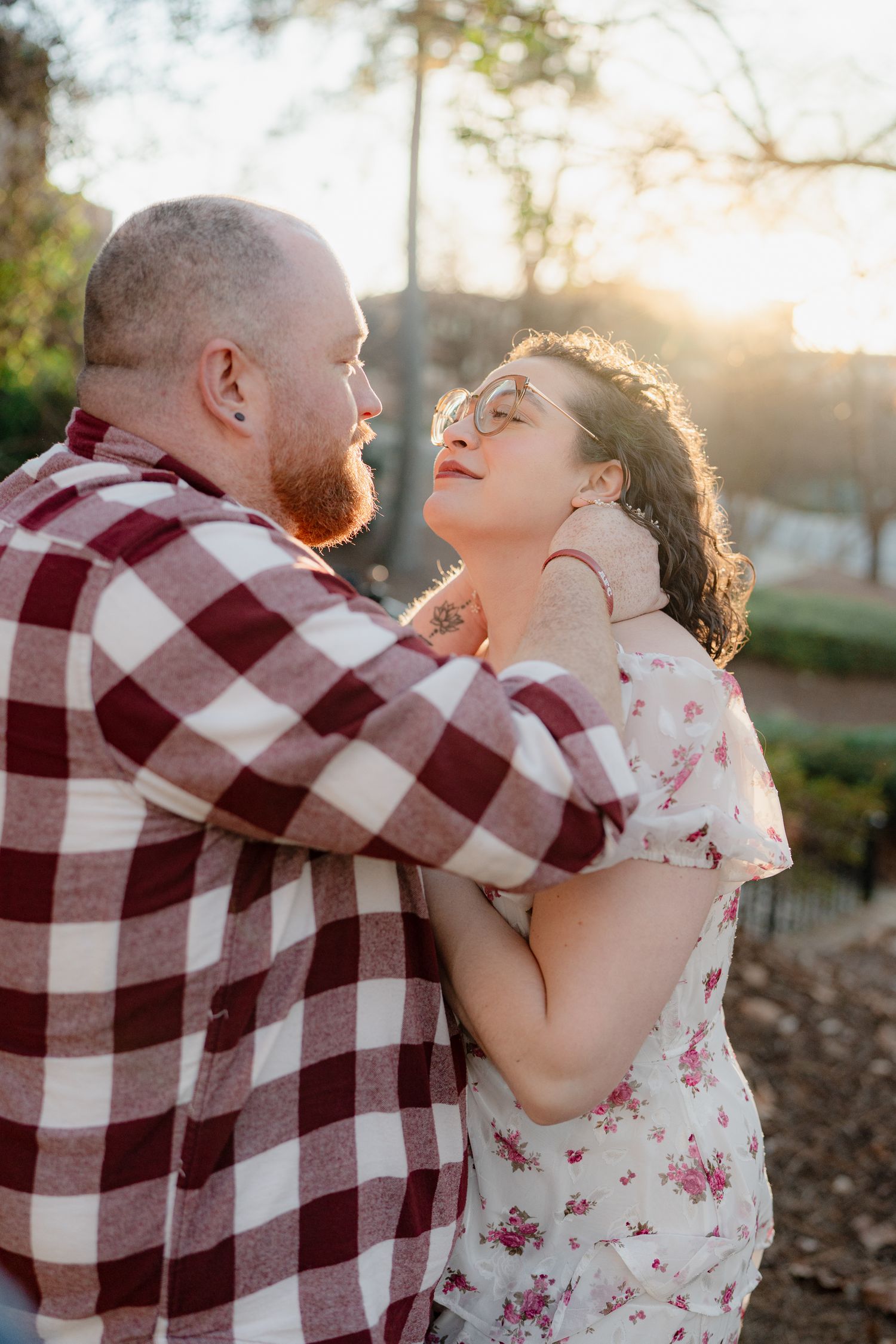 A couple shares tender moments in a series of romantic sunset photos wearing red plaid and floral prints.