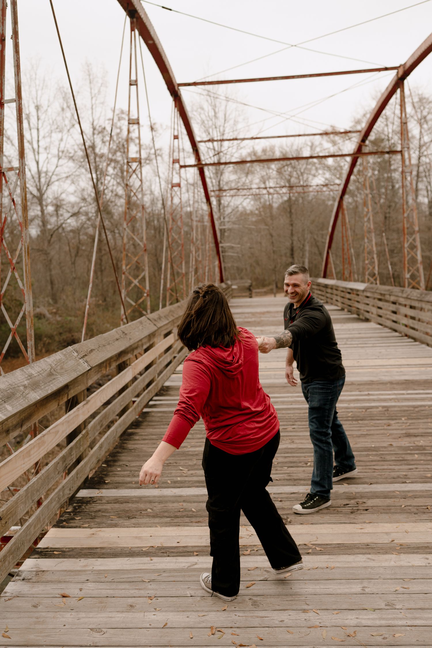 A sequence of photos showing two people playfully chasing each other across a wooden bridge in a winter setting.