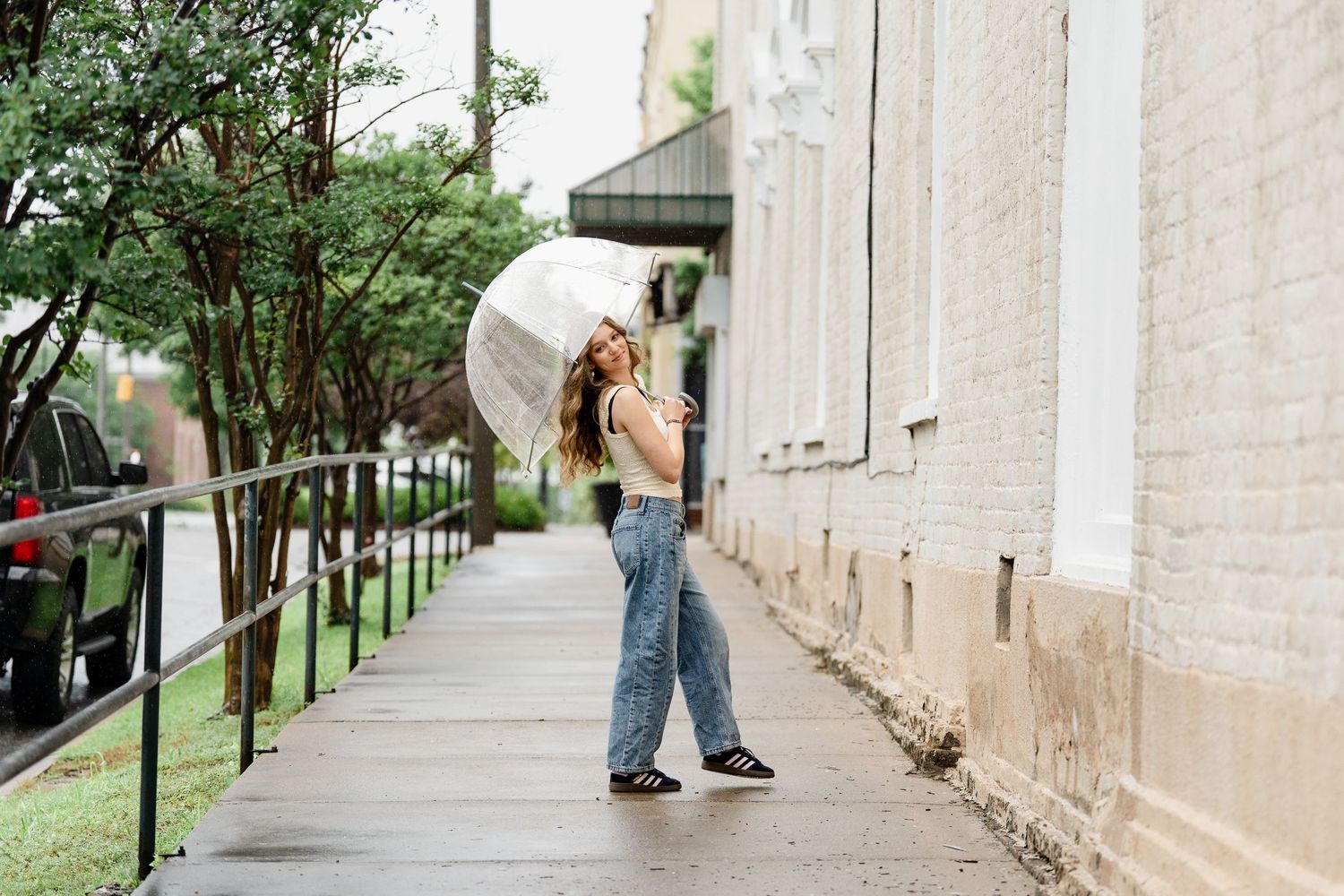 Casual outdoor fashion photography along stone building facade and walkway.