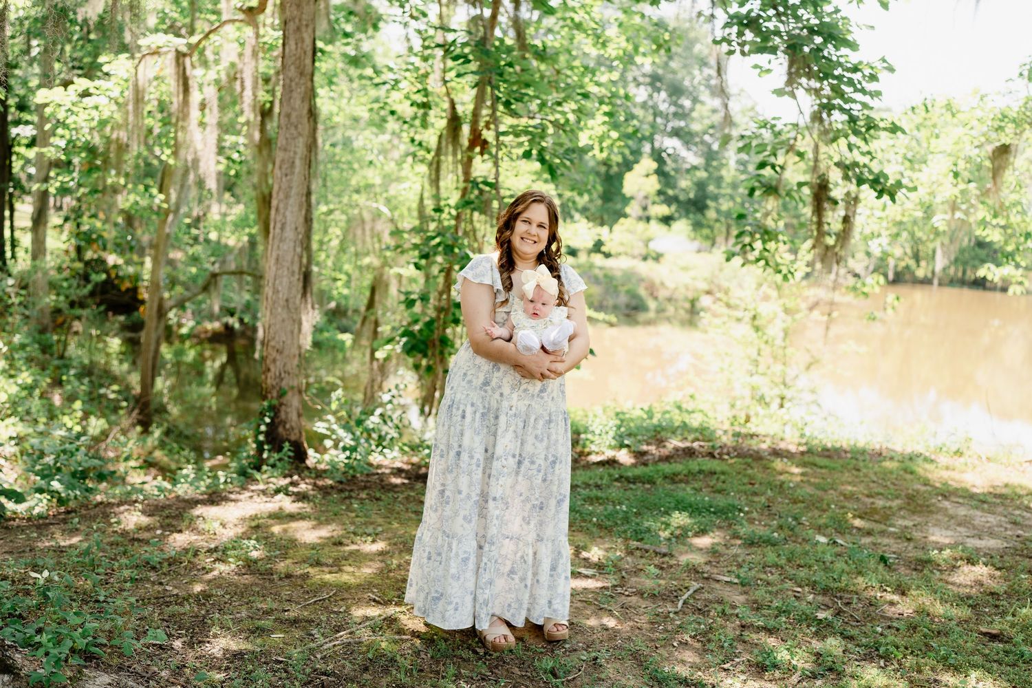 Serene woodland setting with trees and dappled sunlight creating a natural outdoor backdrop.