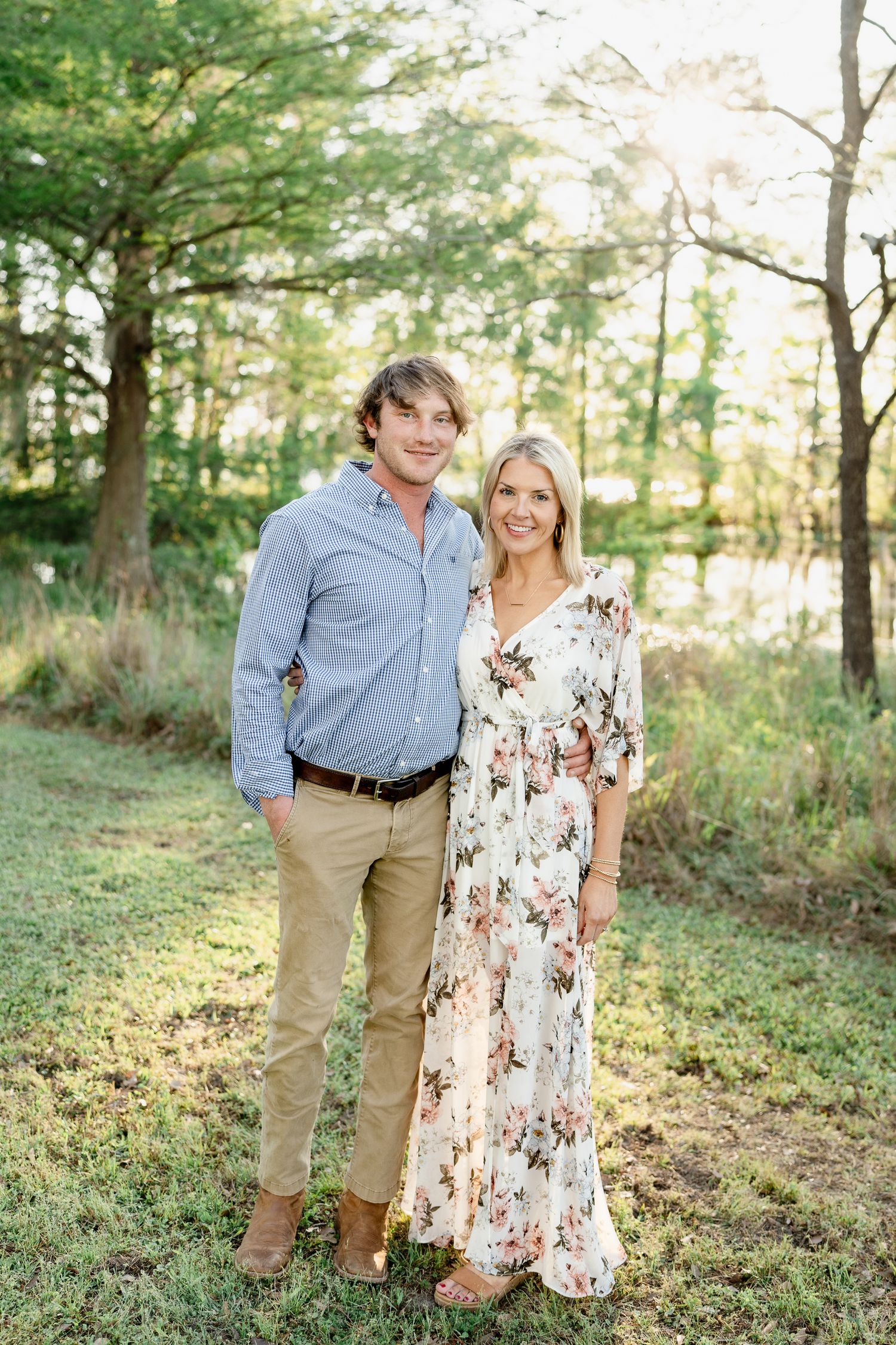 Joyful family portraits taken in a sun-dappled forest setting during golden hour.