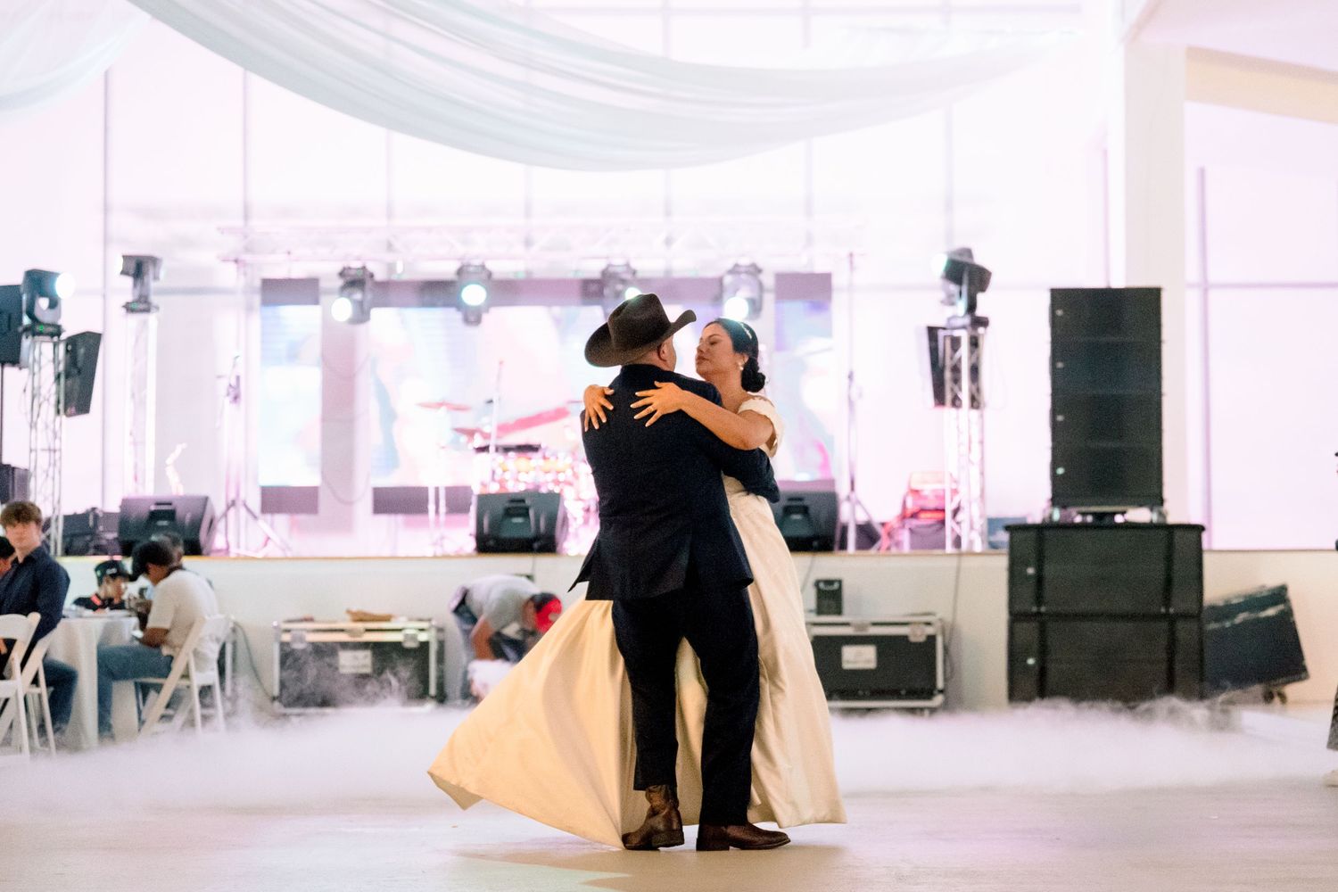 Wedding reception venue with white draping and elegant decor setup for celebration.