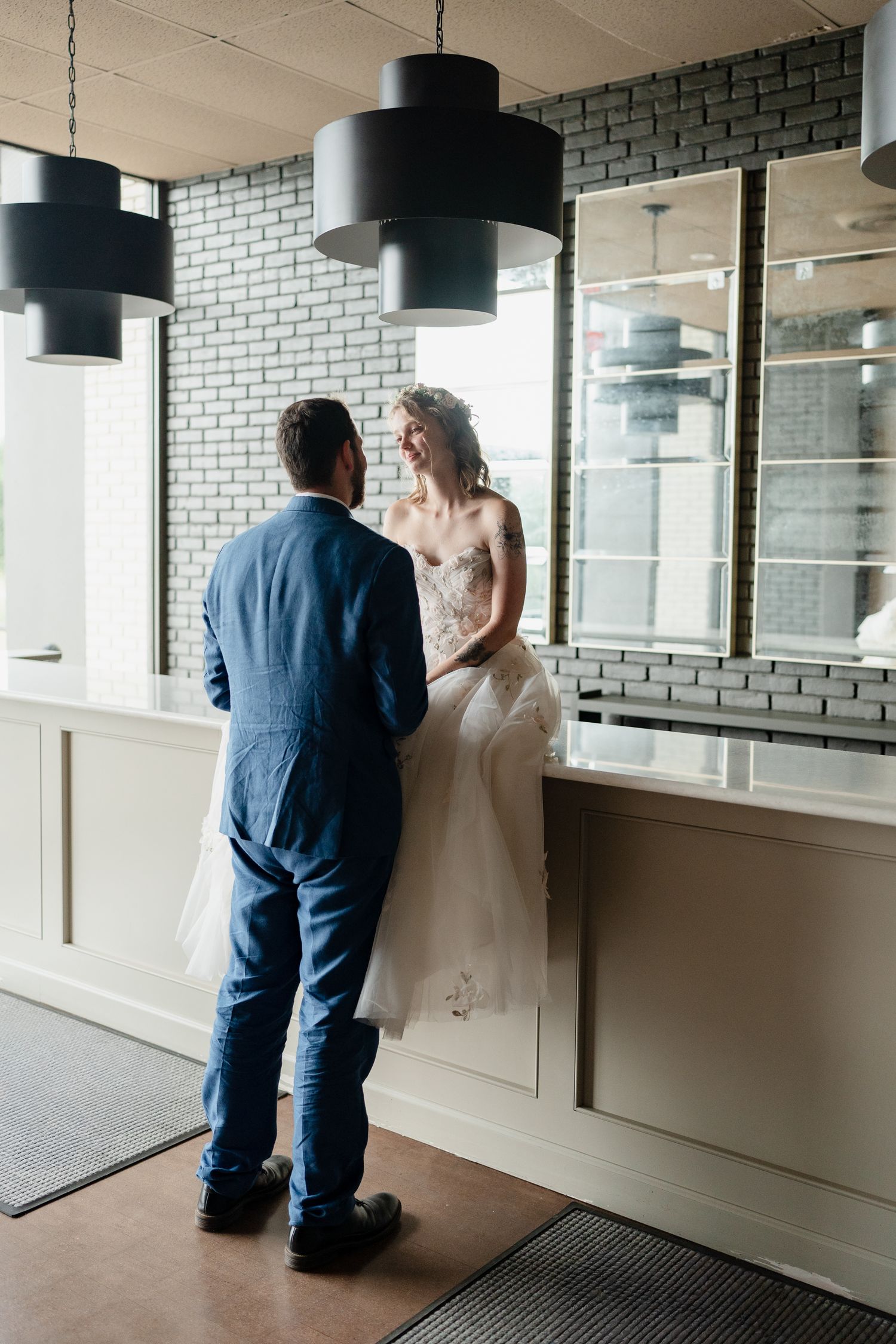 Three sequential photos show a couple in formal attire interacting near a window in a modern interior space.