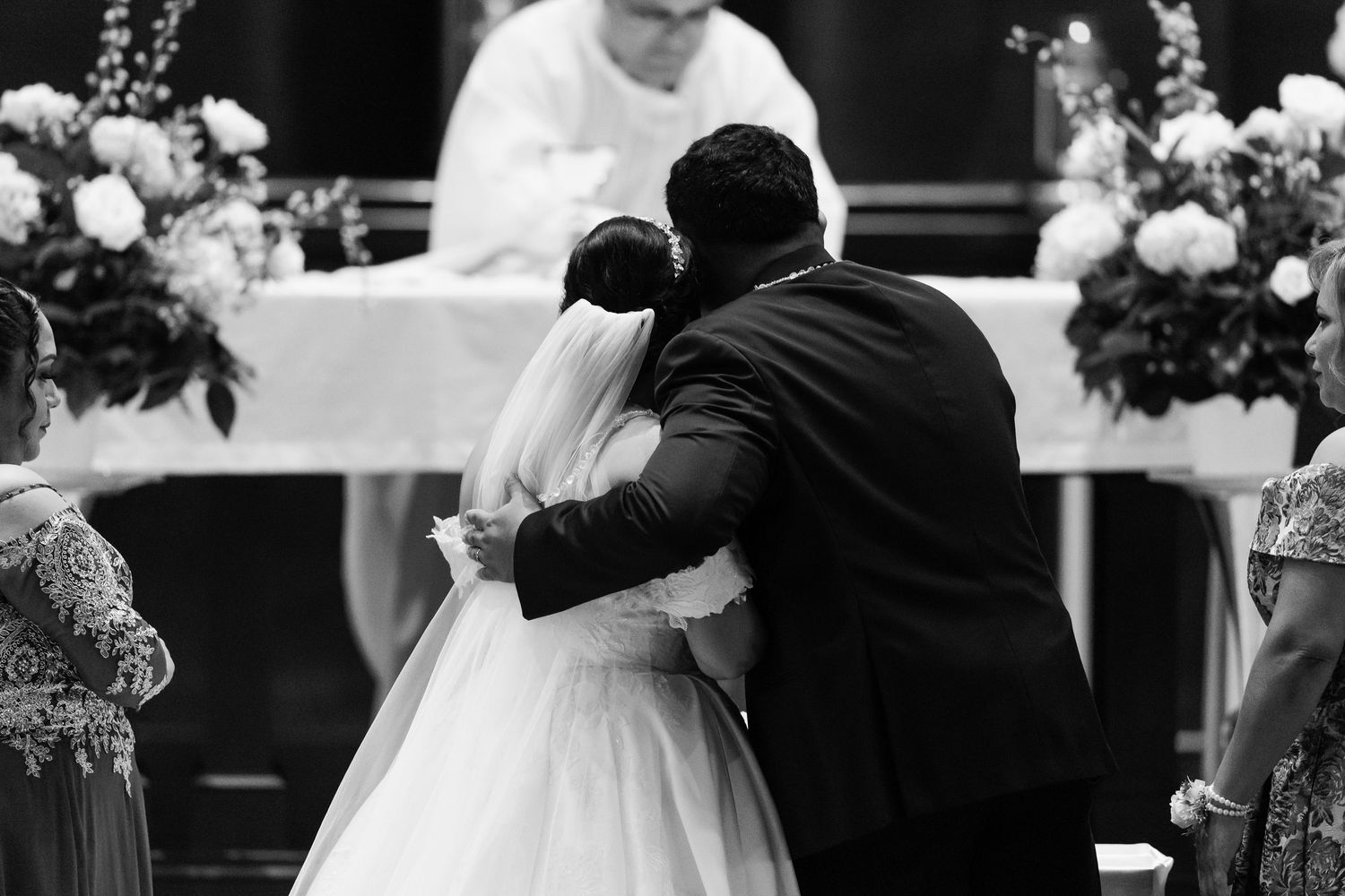 Black and white photo of a couple sharing an intimate moment during their wedding ceremony.