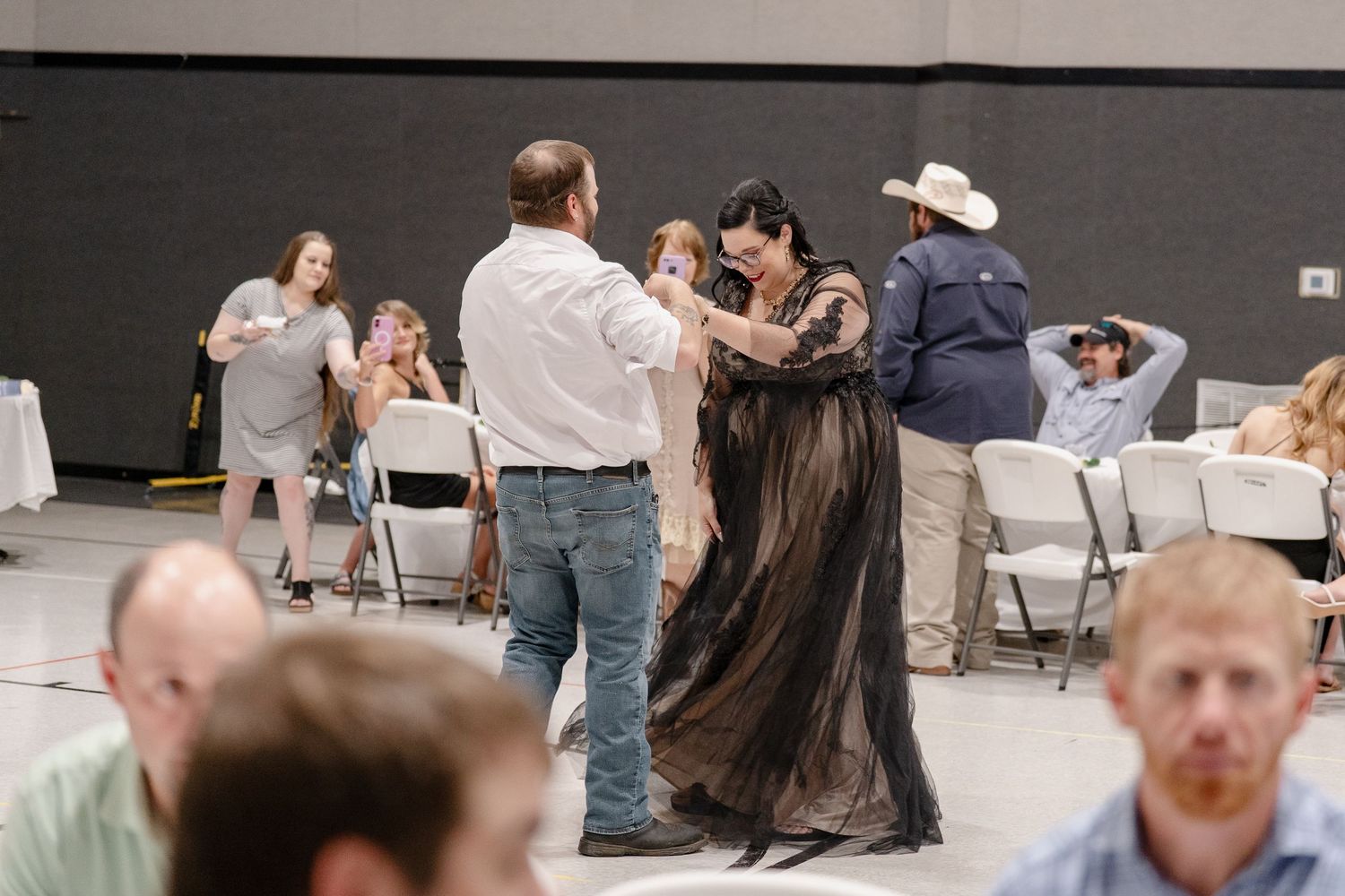 Wedding reception guests line up in a formation while participating in a group activity.