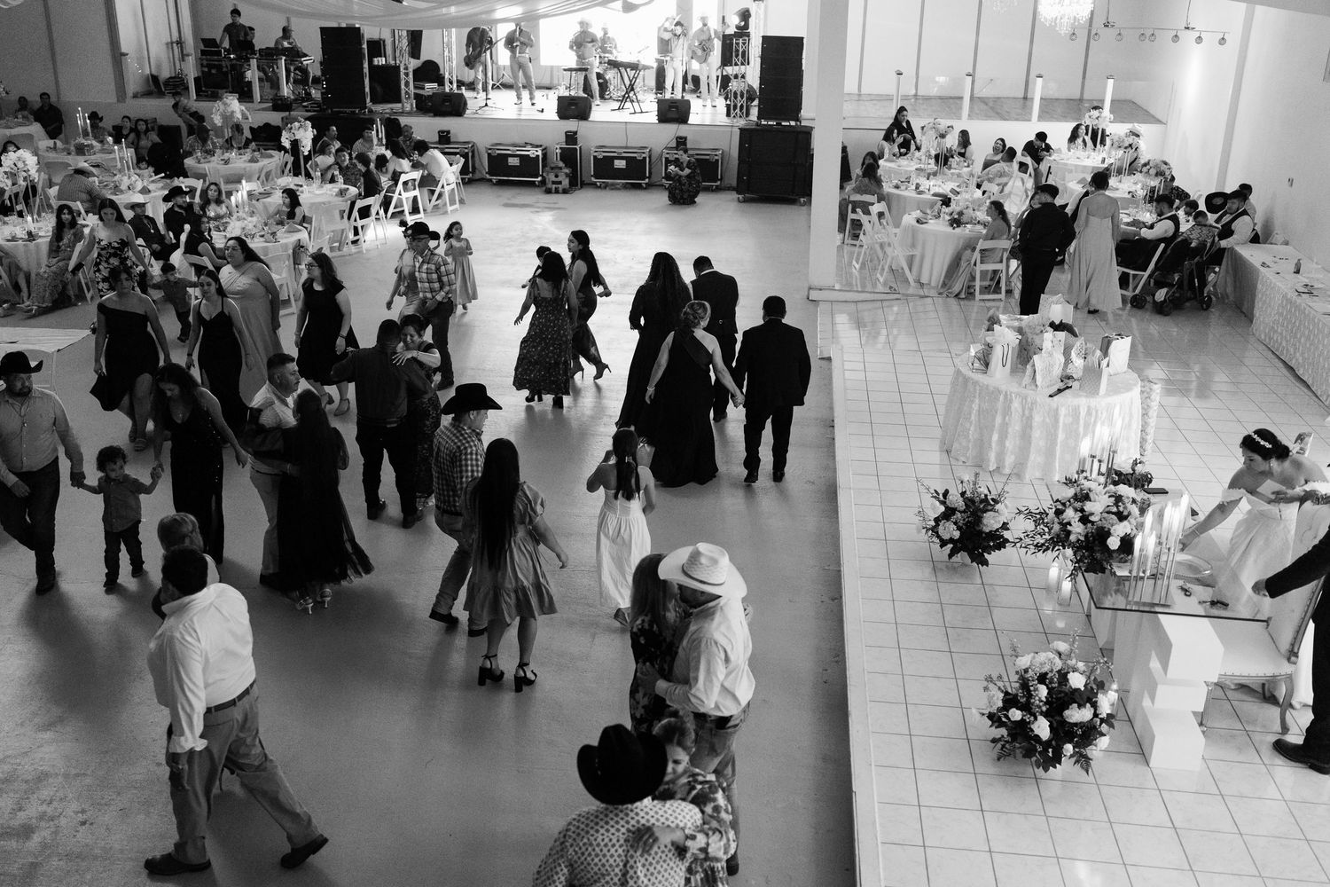 Wide view of wedding reception hall showing guests mingling and dancing.