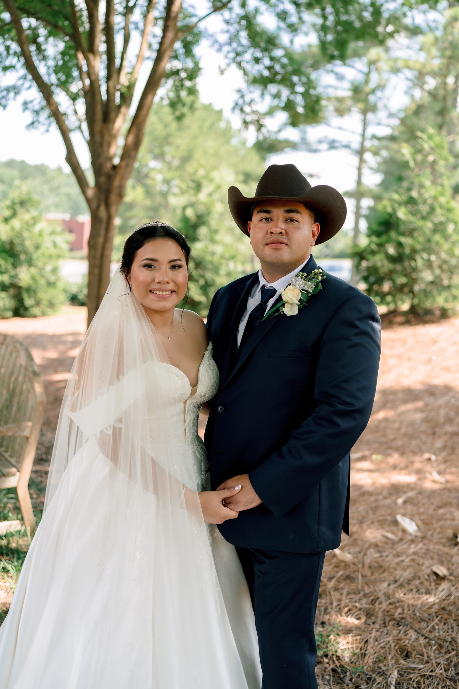A couple in wedding attire poses outdoors against a natural wooded backdrop in a series of romantic portraits.